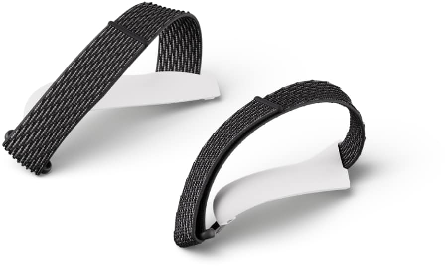 Zwei schwarz-weiße VR-Headset-Träger liegen auf einer weißen Oberfläche, Schrägansicht.