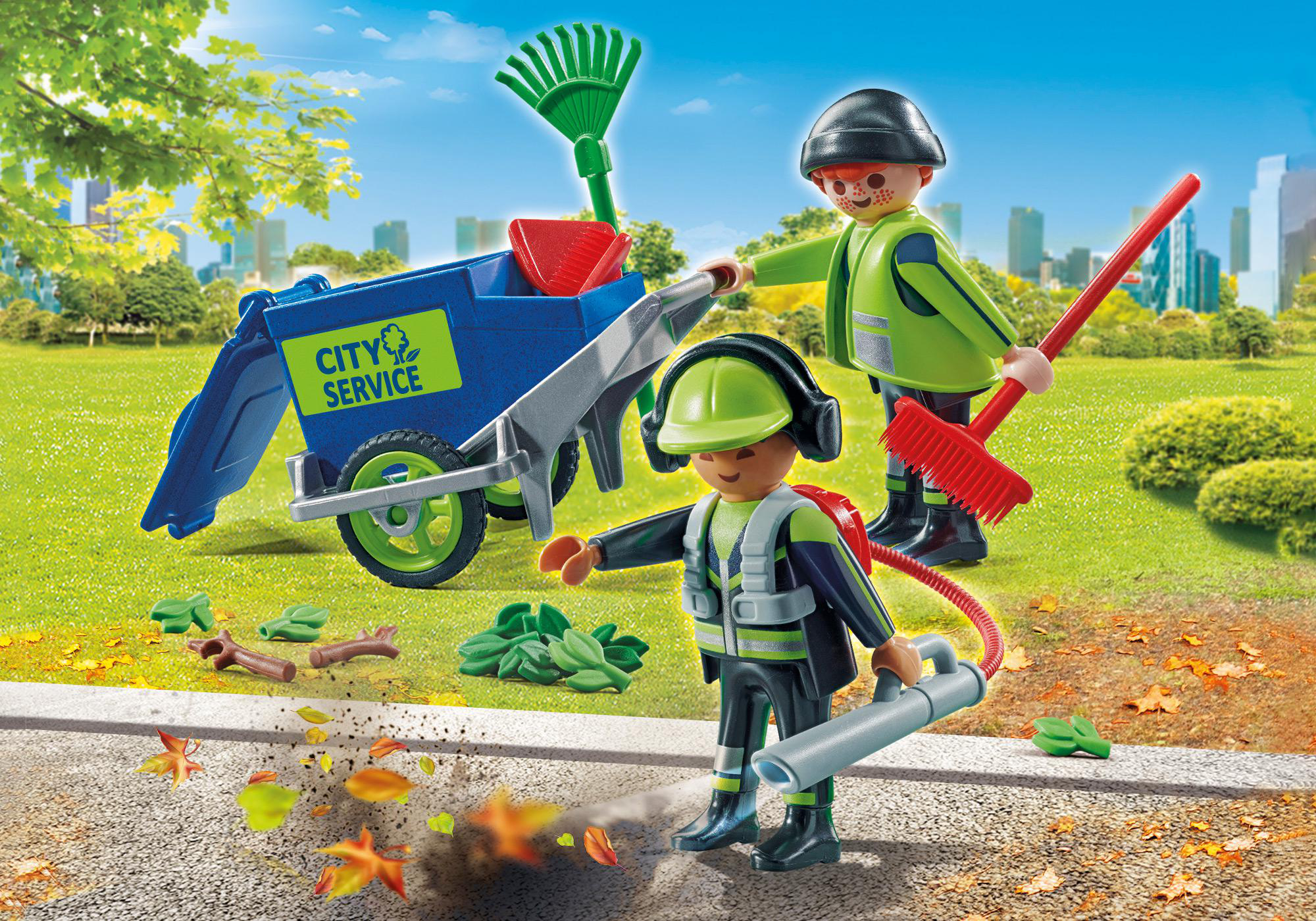 Zwei Playmobil-Figuren reinigen einen Park. Einer benutzt ein Laubgebläse, der andere eine Harke und Schubkarre.