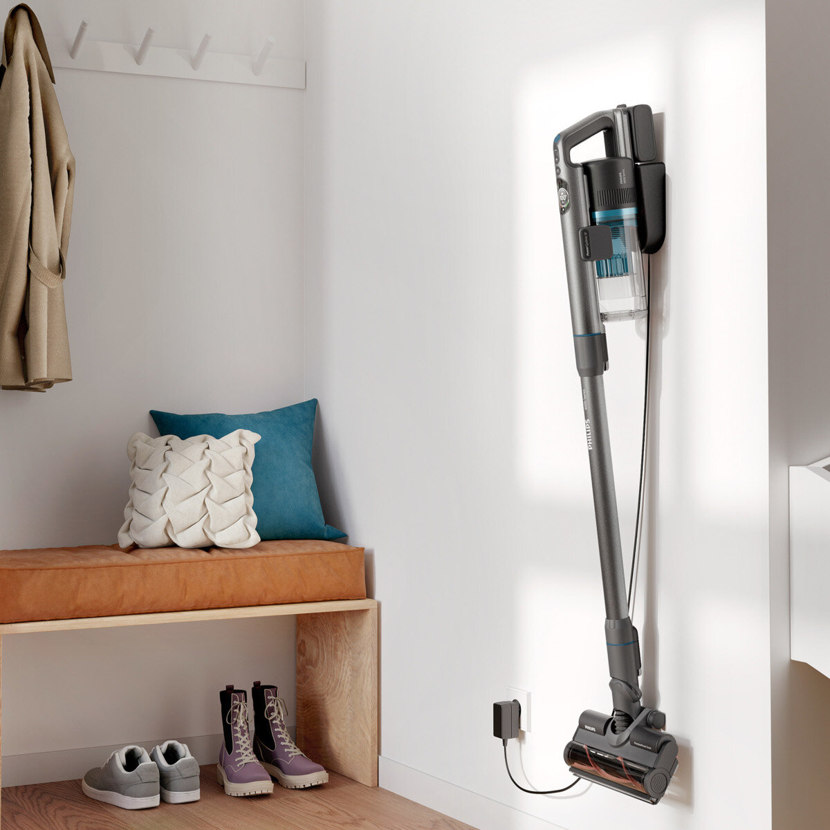 Odkurzacz ładujący się na ścianie. Jest ławka z butami i wieszak na ubrania.