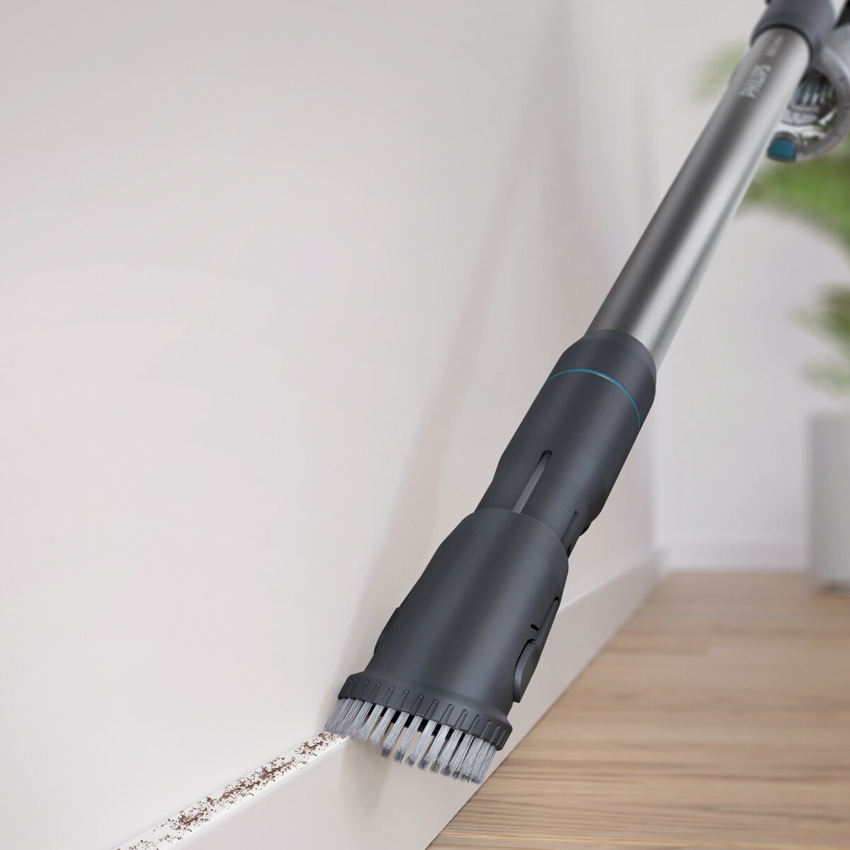 Głowica odkurzacza bezprzewodowego czyszcząca białą ścianę, widoczny kurz.