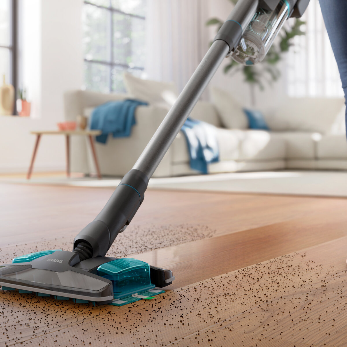 Odkurzacz czyszczący drewnianą podłogę z rozrzuconymi na niej zanieczyszczeniami.