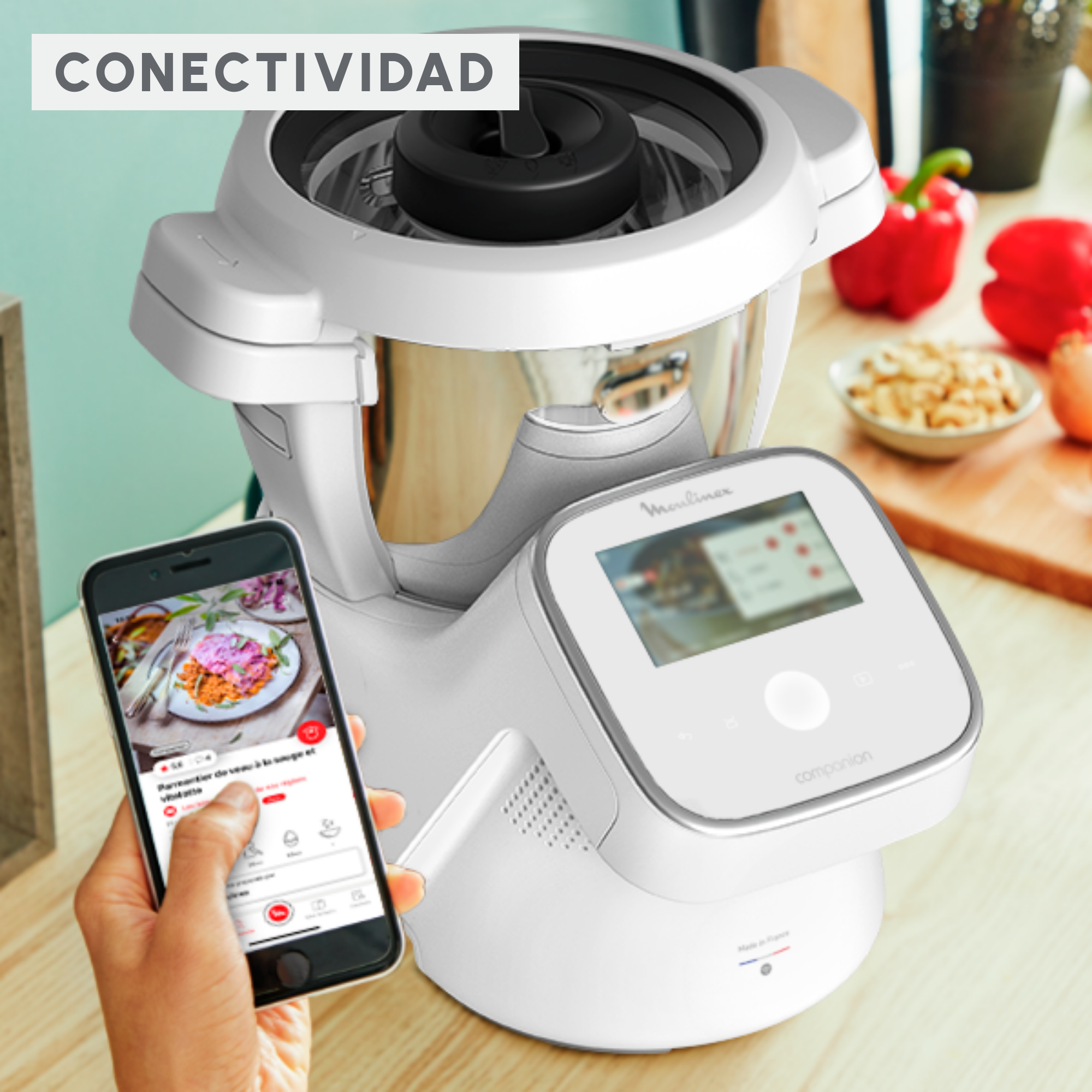 Robot de cocina Moulinex Companion blanco con un smartphone mostrando una receta.