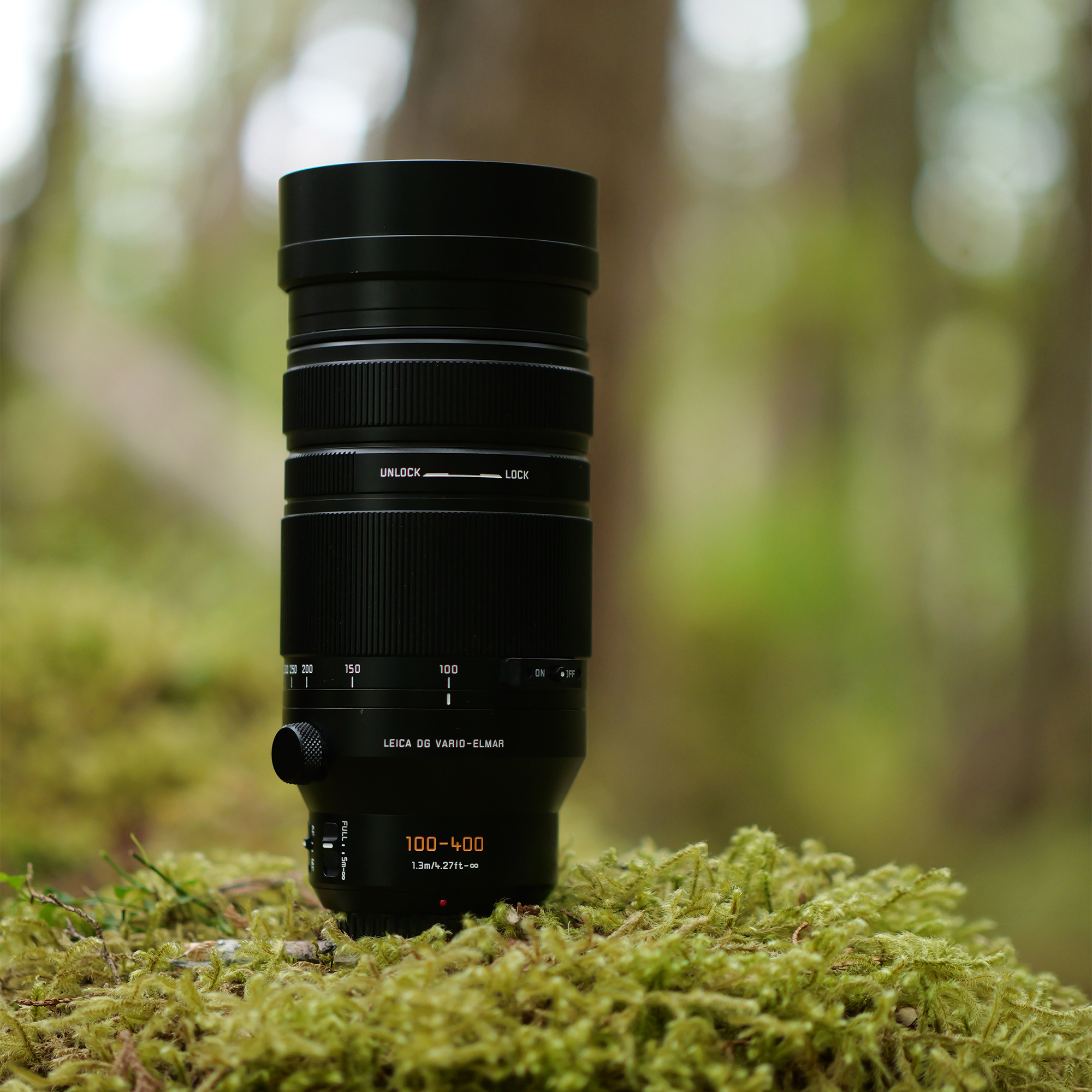 Objectif Leica noir sur de la mousse en forêt. Détails : 100-400mm.