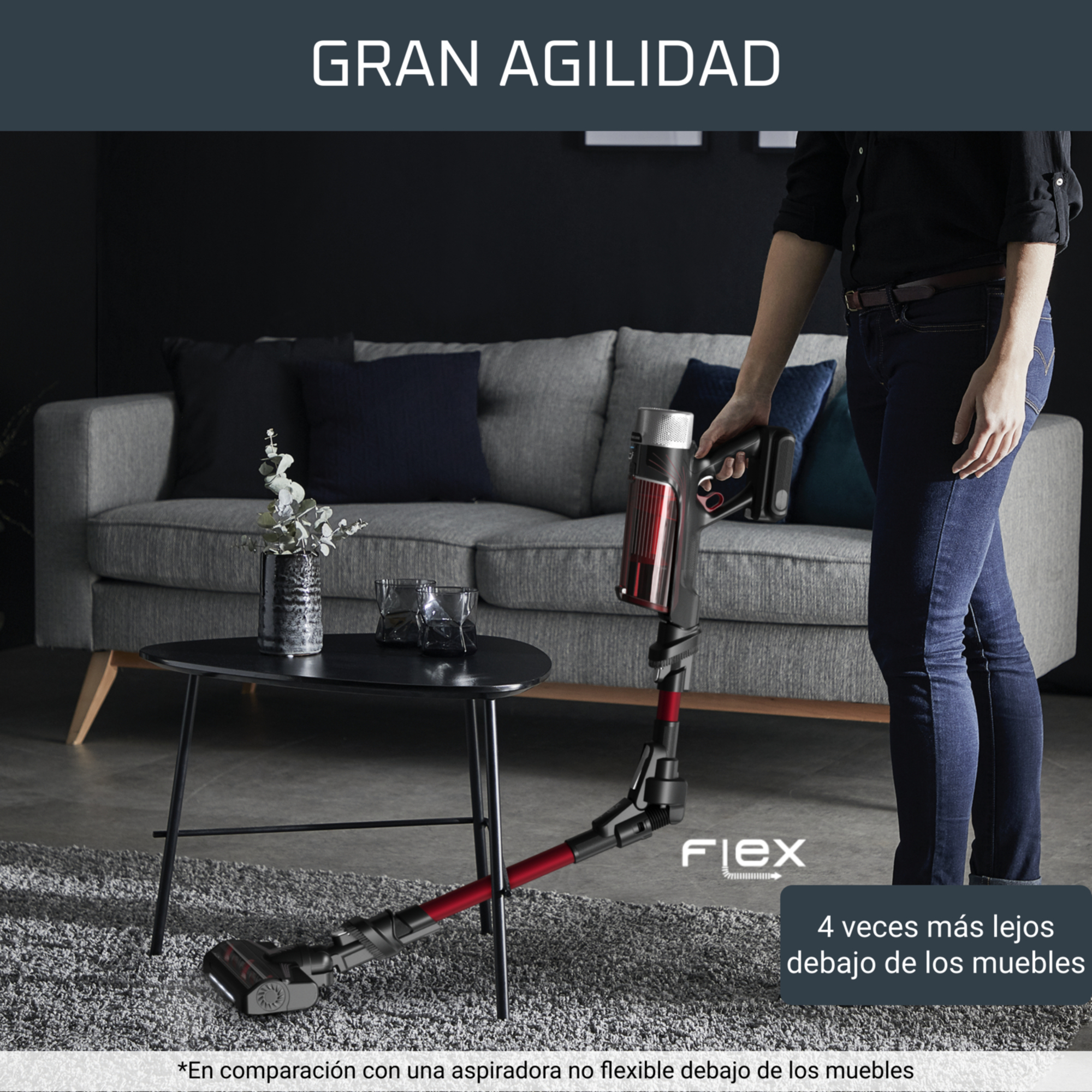 Una persona usando una aspiradora roja y negra.