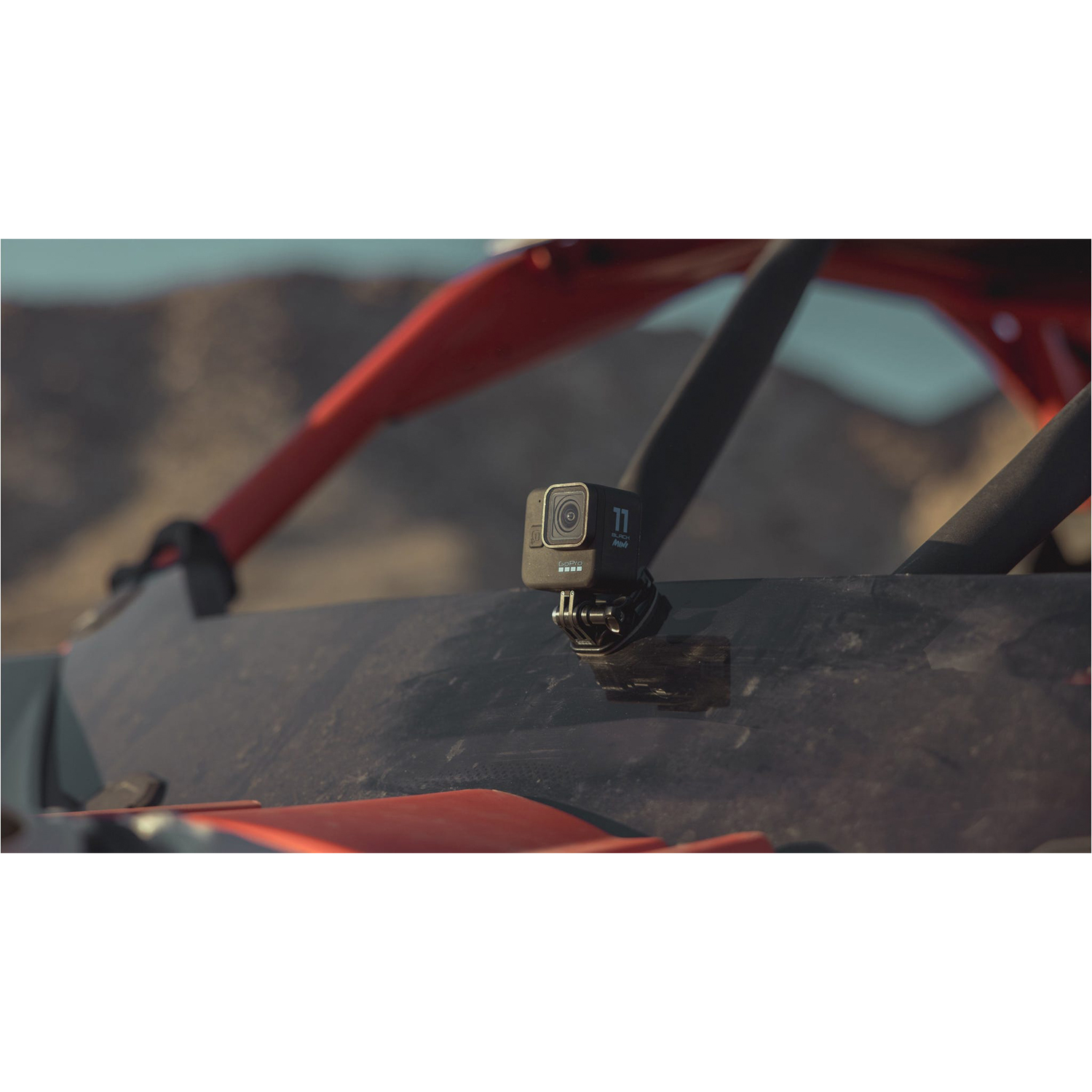 Una fotocamera GoPro montata su un veicolo, con un terreno accidentato sullo sfondo.