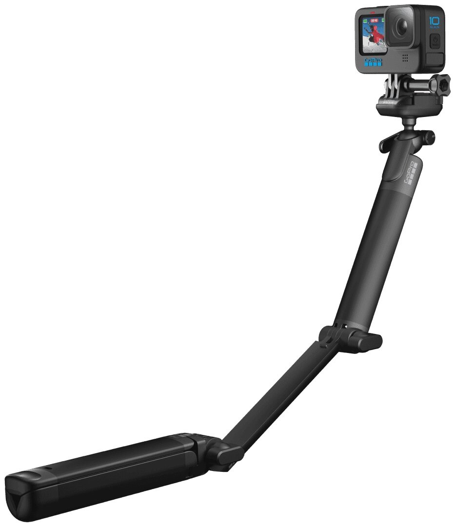 Czarna kamera sportowa przymocowana do wysuwanego kija do selfie, skierowana w górę.