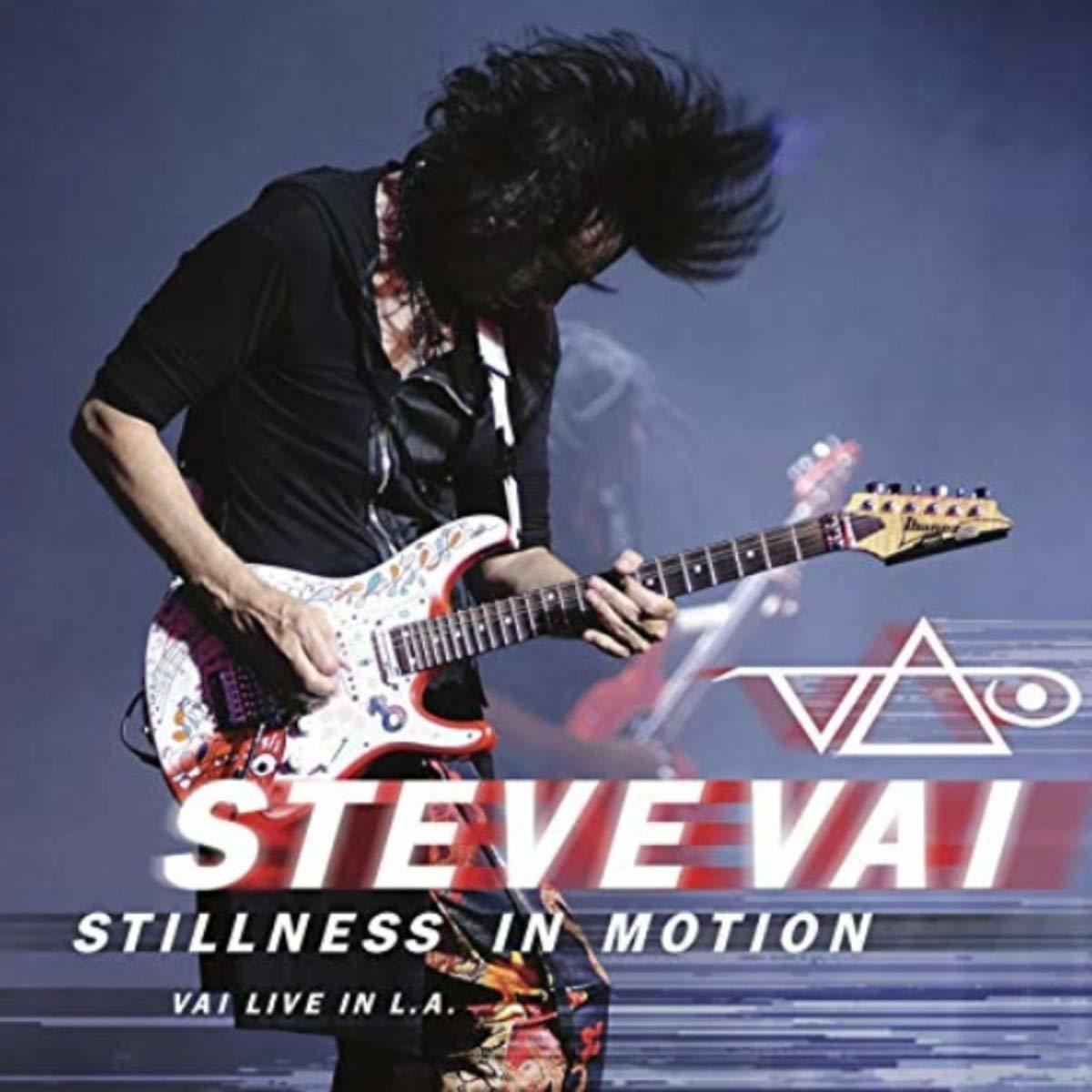 Steve Vai gitározik. Hosszú, fekete haja van. Az album címe: "Stillness in Motion". A háttér kék.
