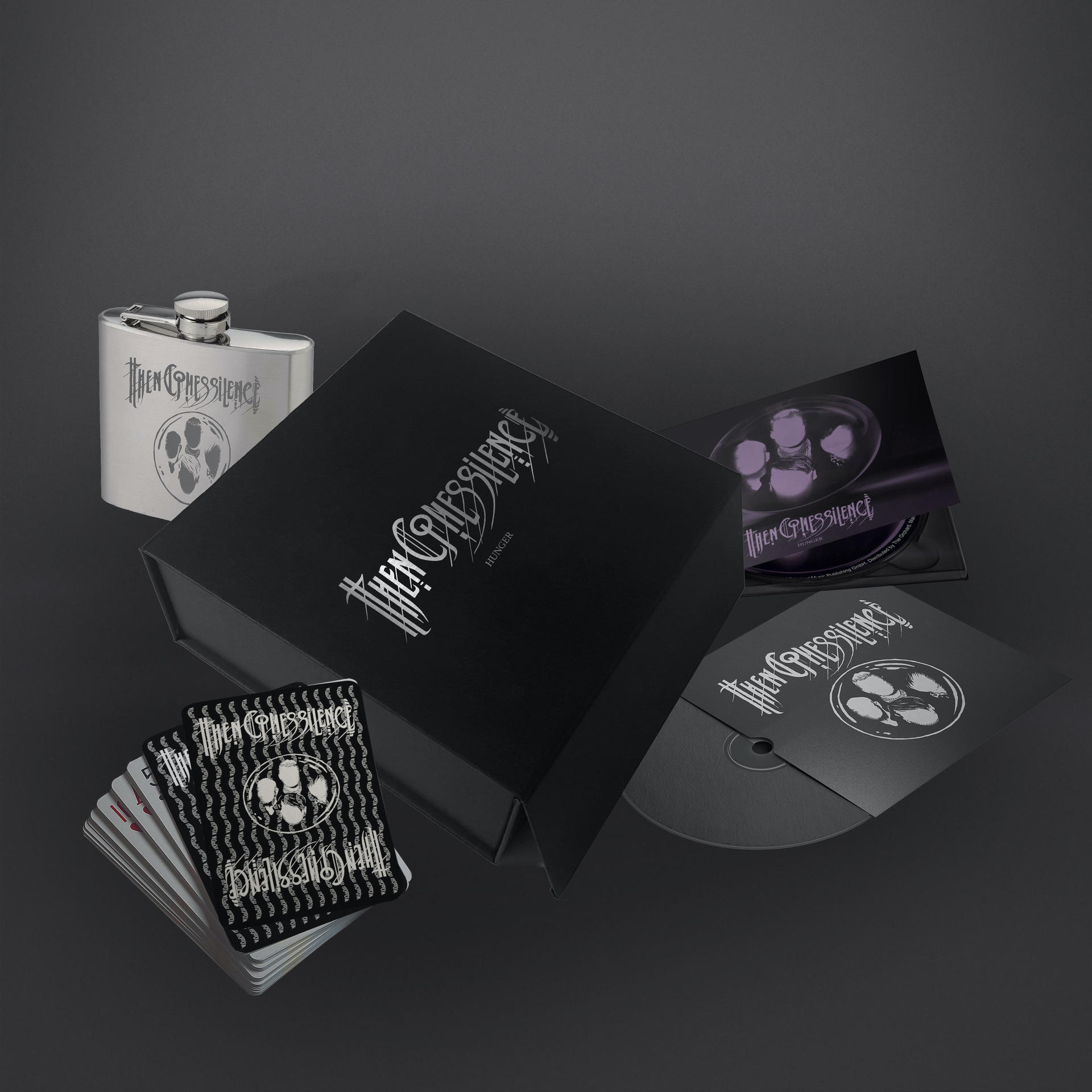 Ein schwarzes Box-Set mit Flasche, Karten, CD und anderen Artikeln, alle mit 'Then Silence' beschriftet.