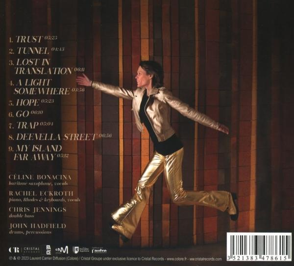 CD-Cover mit Frau in Gold, springend. Trackliste und Namen der Musiker, brauner Hintergrund.