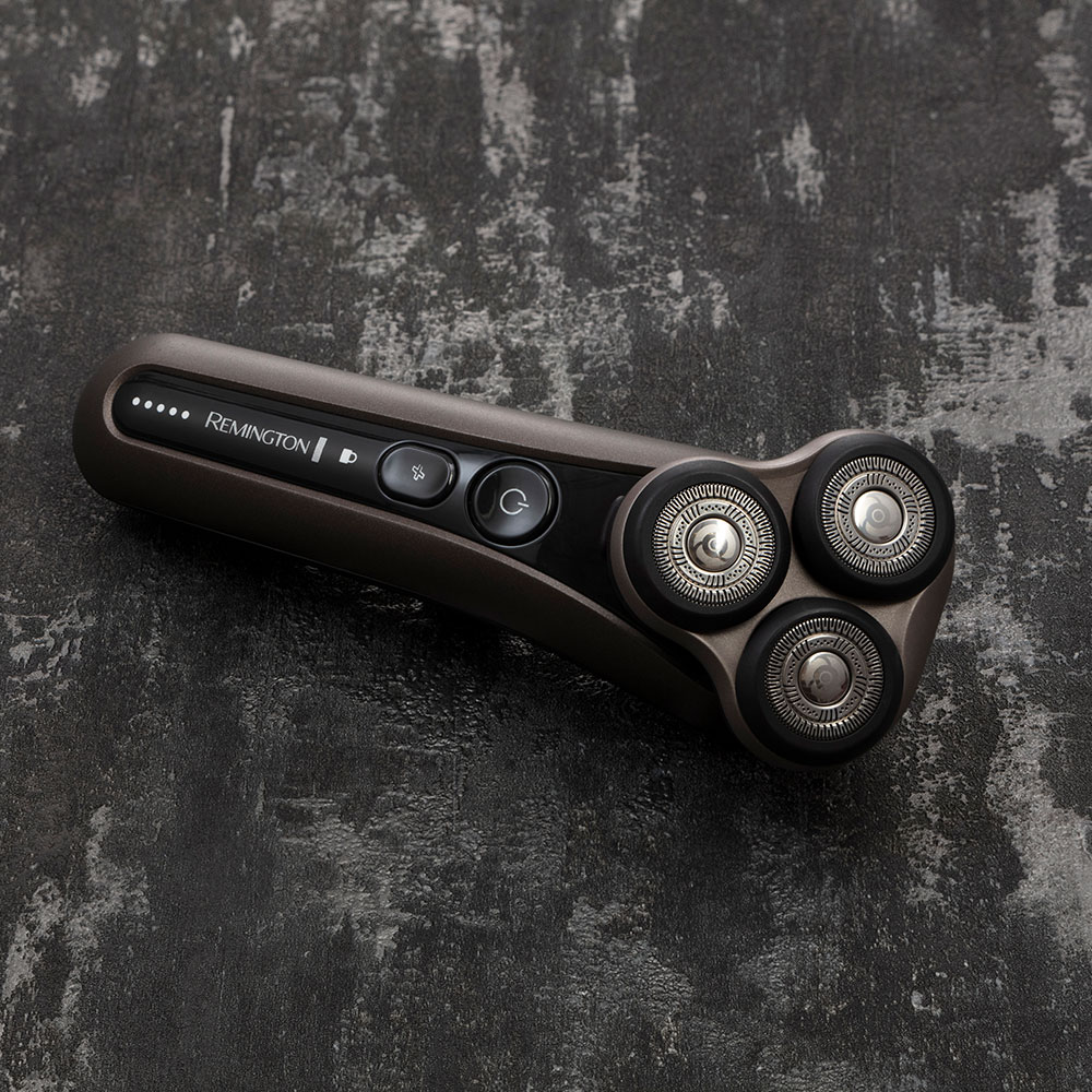 Remington elektromos borotva szürke textúrázott felületen.
