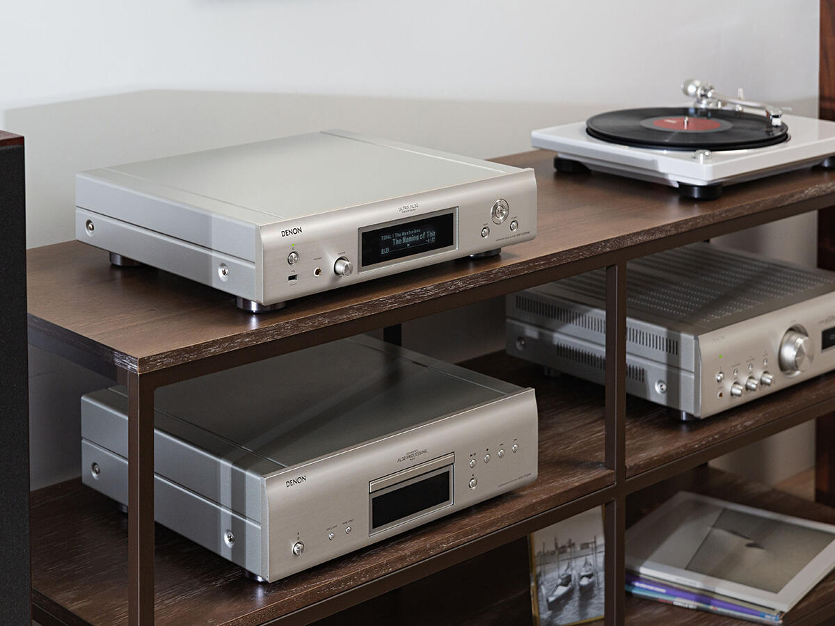 Stereoanlage auf einem Regal: CD-Player, Verstärker und Plattenspieler.