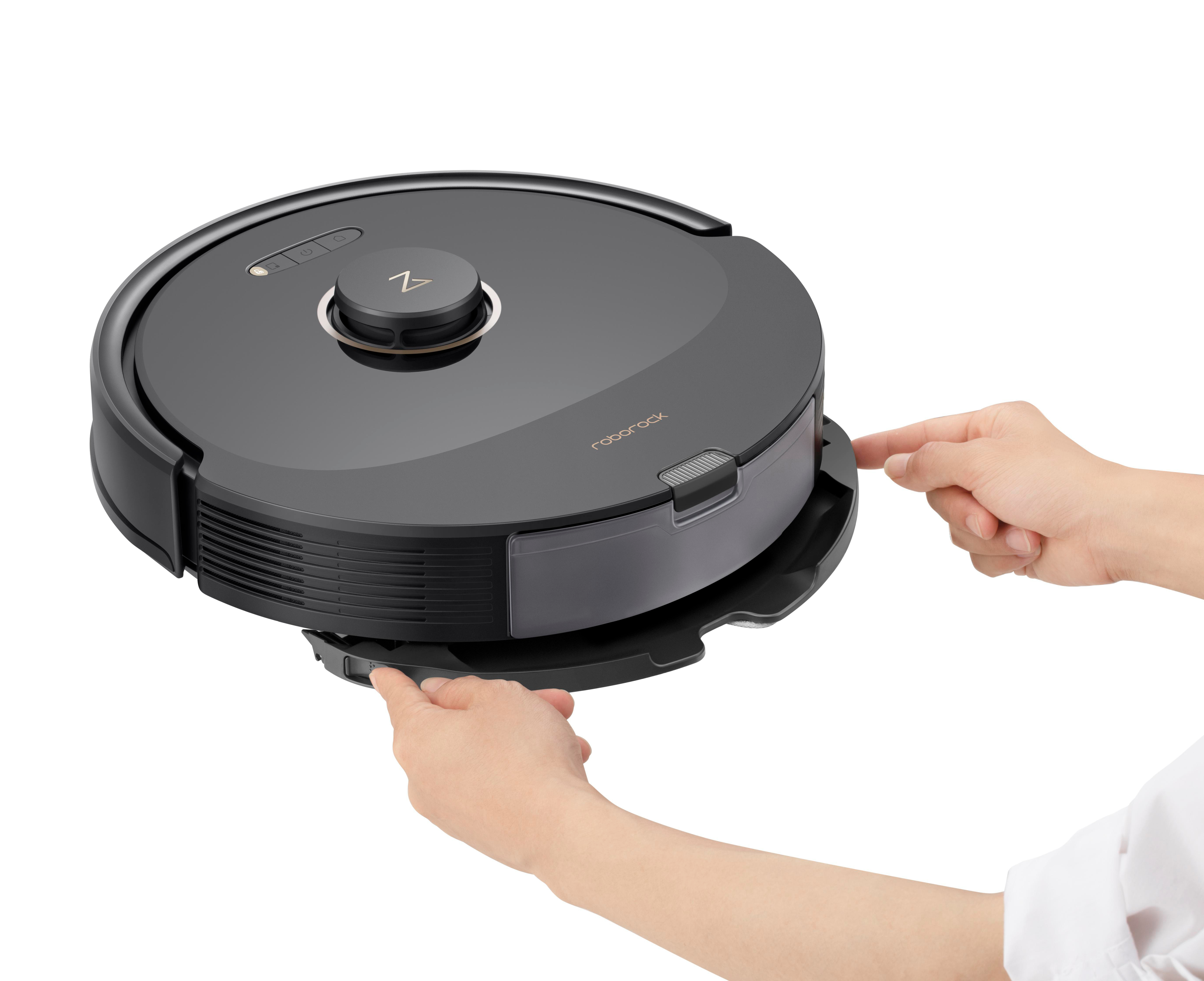 Ein schwarzer Roboter-Staubsauger wird von zwei Händen geöffnet. Die Hände ziehen den Staubbehälter heraus.