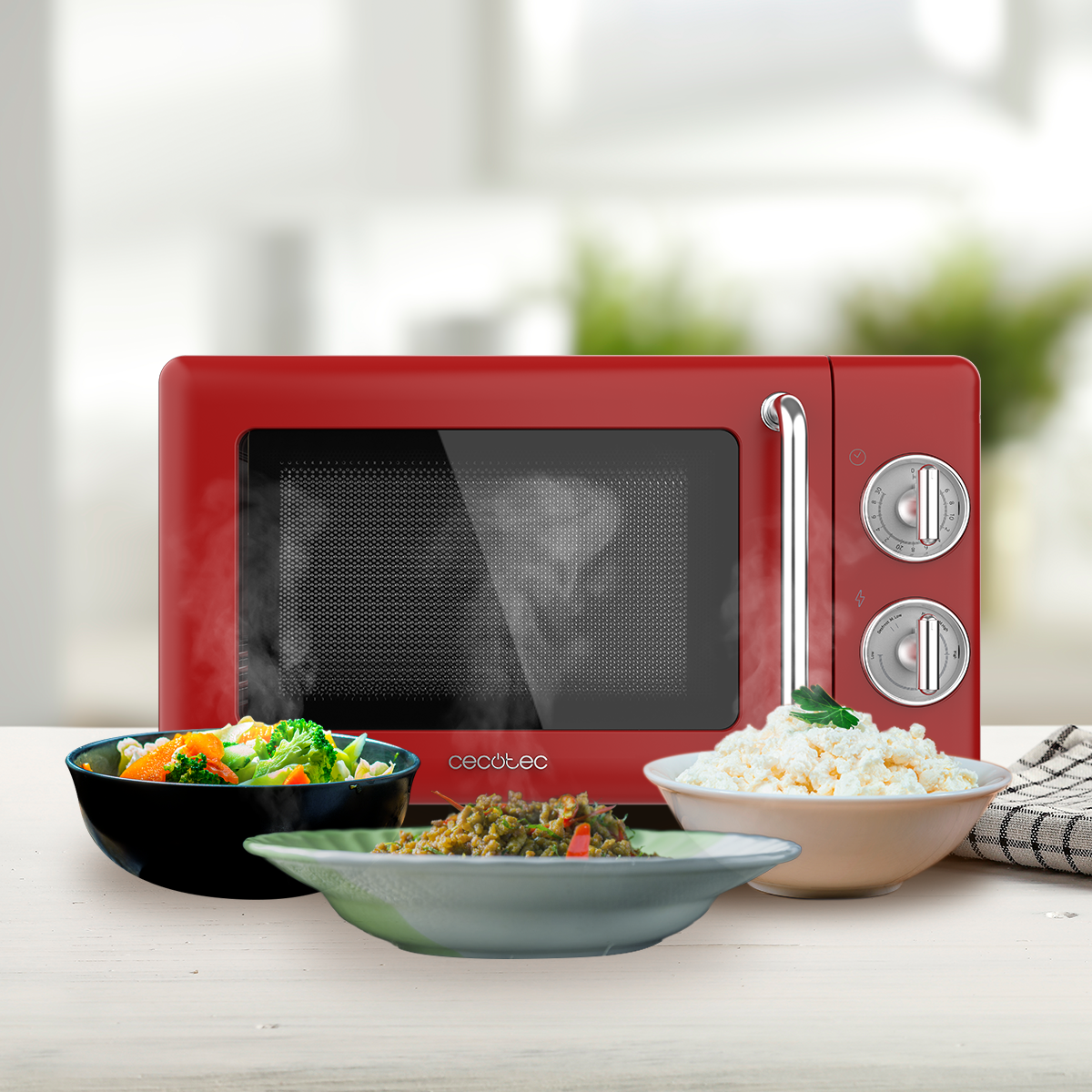 Microondas rojo con cuencos de comida, vapor ascendente, sobre mesa blanca, fondo borroso.