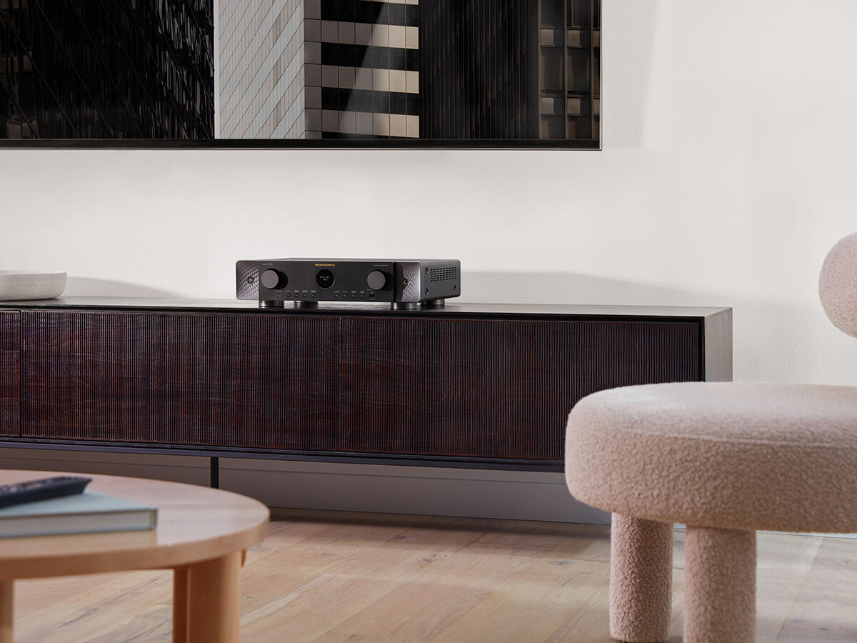 Marantz-Receiver auf einem Holzschrank. Ein Fernseher darüber und ein runder Tisch vorne.