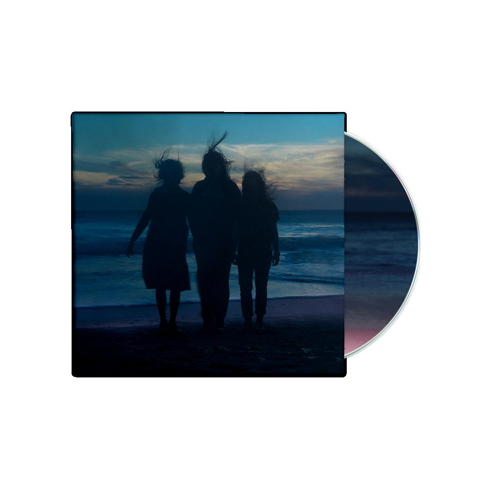CD-Hülle mit einem dunklen Bild von drei Personen am Strand in der Abenddämmerung.