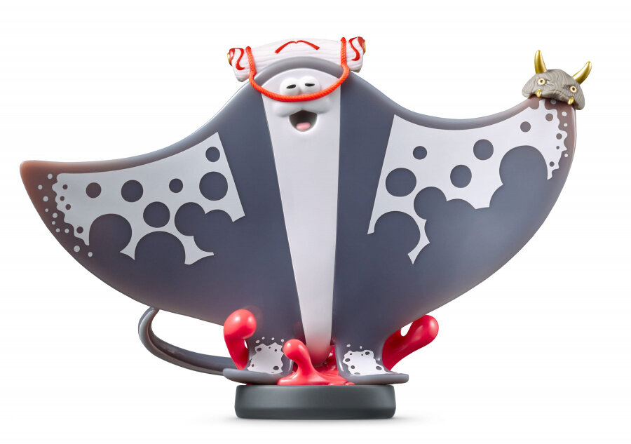 Zabawkowa figura płaszczki: szara i biała, uśmiechnięta, z czerwonymi ustami i małą figurką na górze.