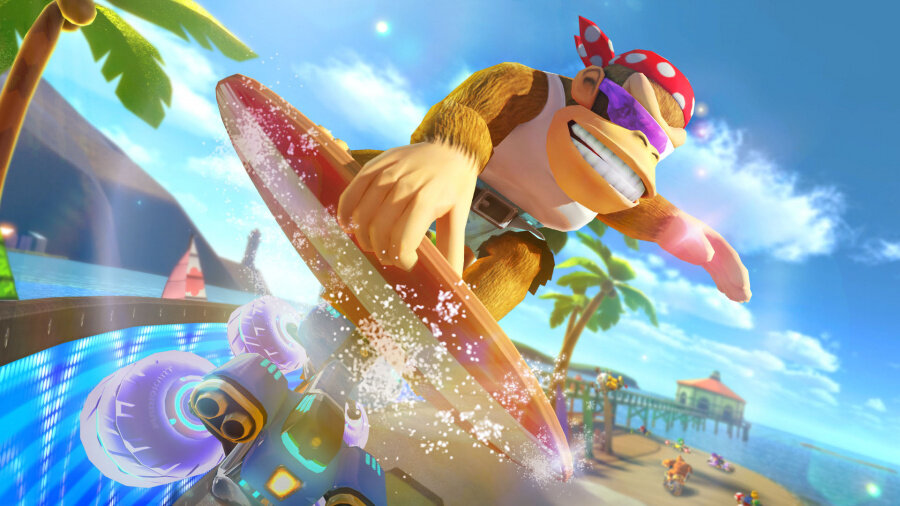 Donkey Kong surfuje na czerwonej desce surfingowej, z niebieską falą i tłem plaży.