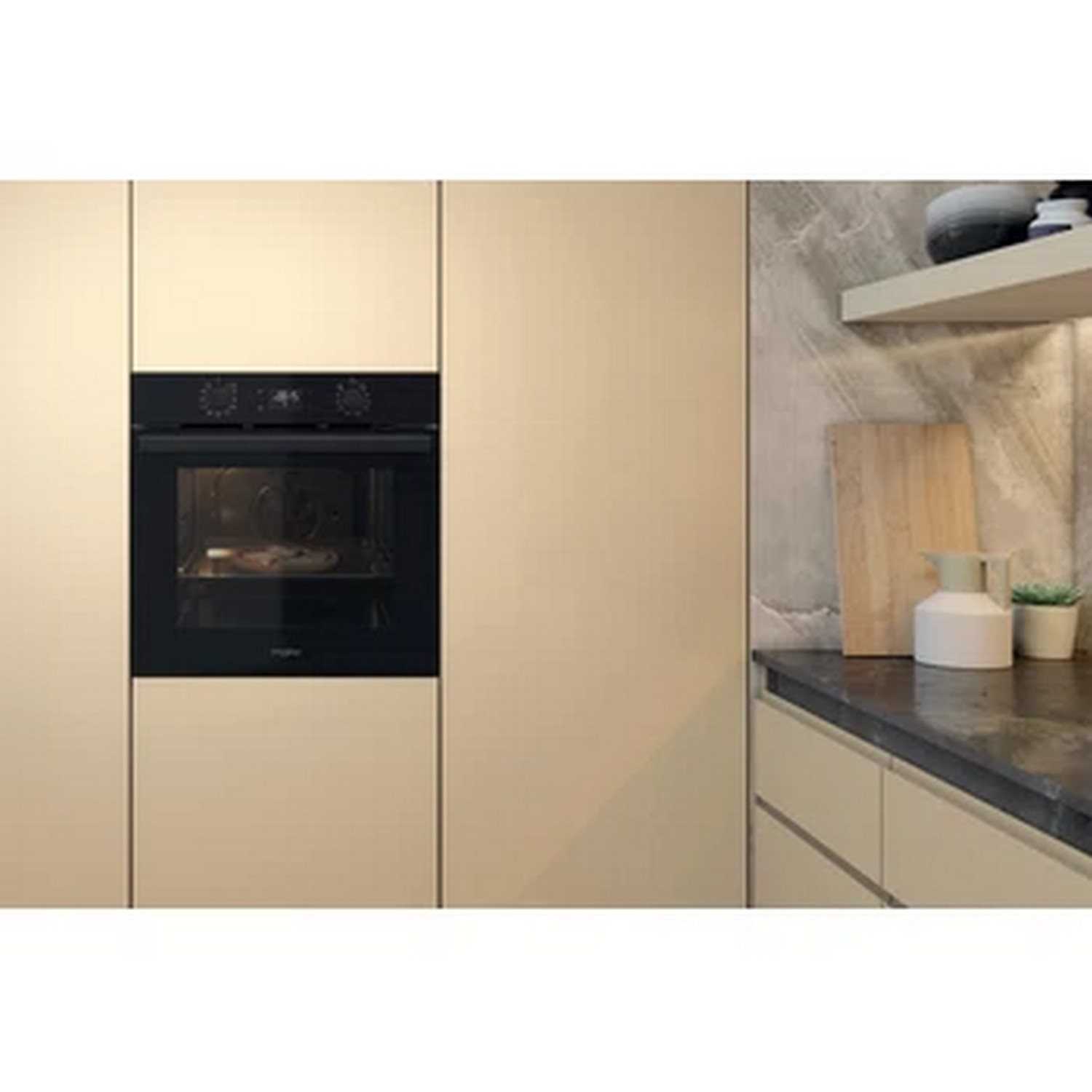 Un four noir est dans une armoire de cuisine beige clair.