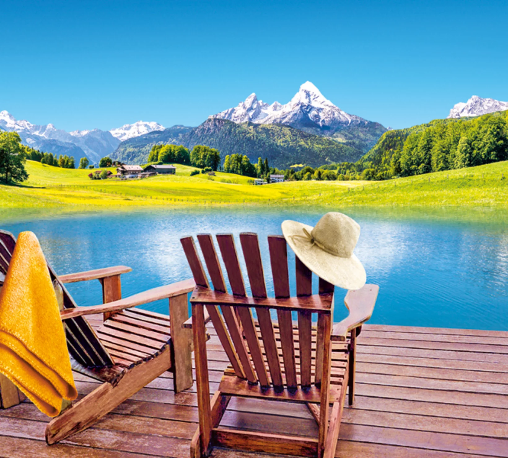 Vista panoramica con lago, montagne e due sedie di legno su un molo, con cappello e asciugamano giallo.