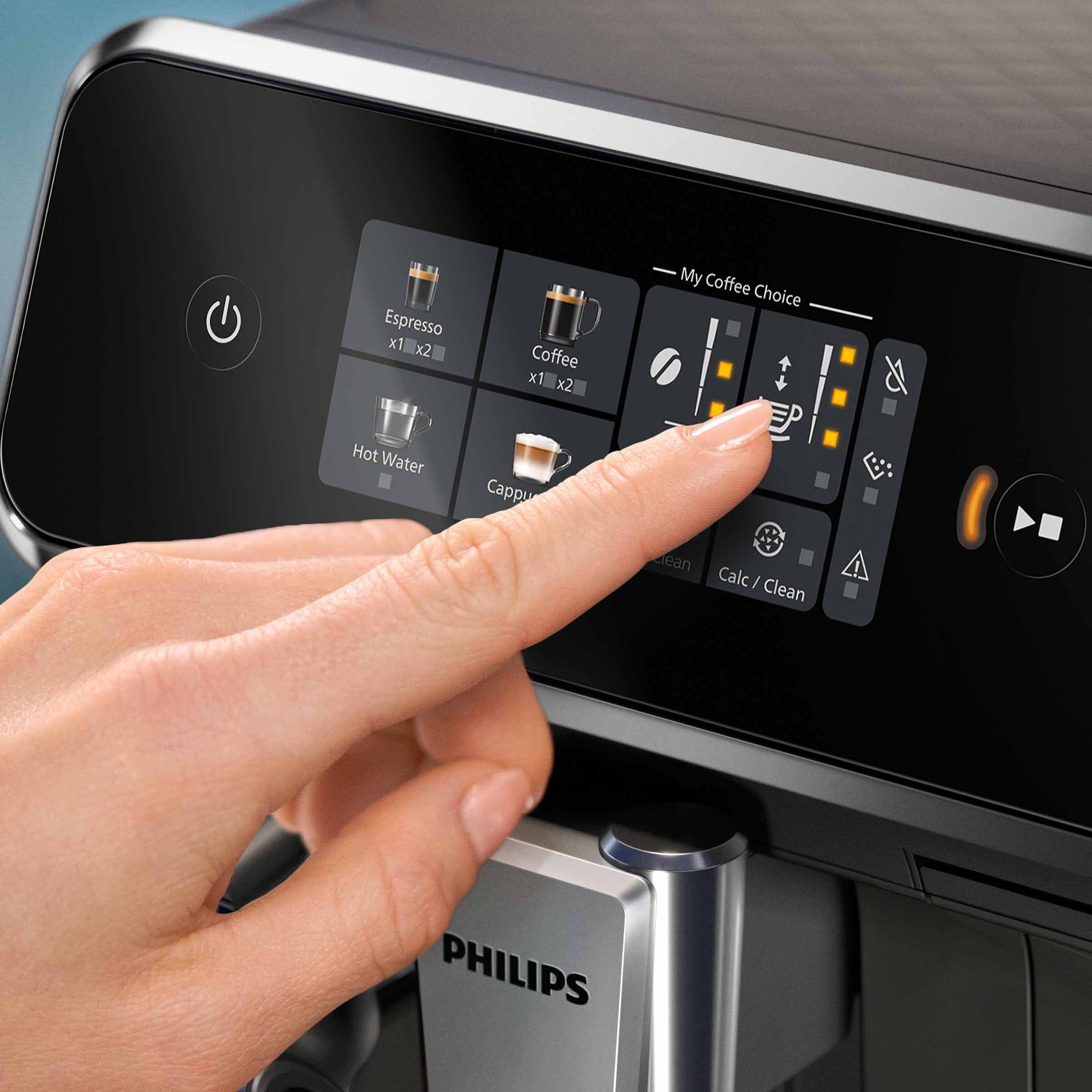 Dłoń dotyka ekranu ekspresu do kawy. Ekran wyświetla opcje i ikony kawy.