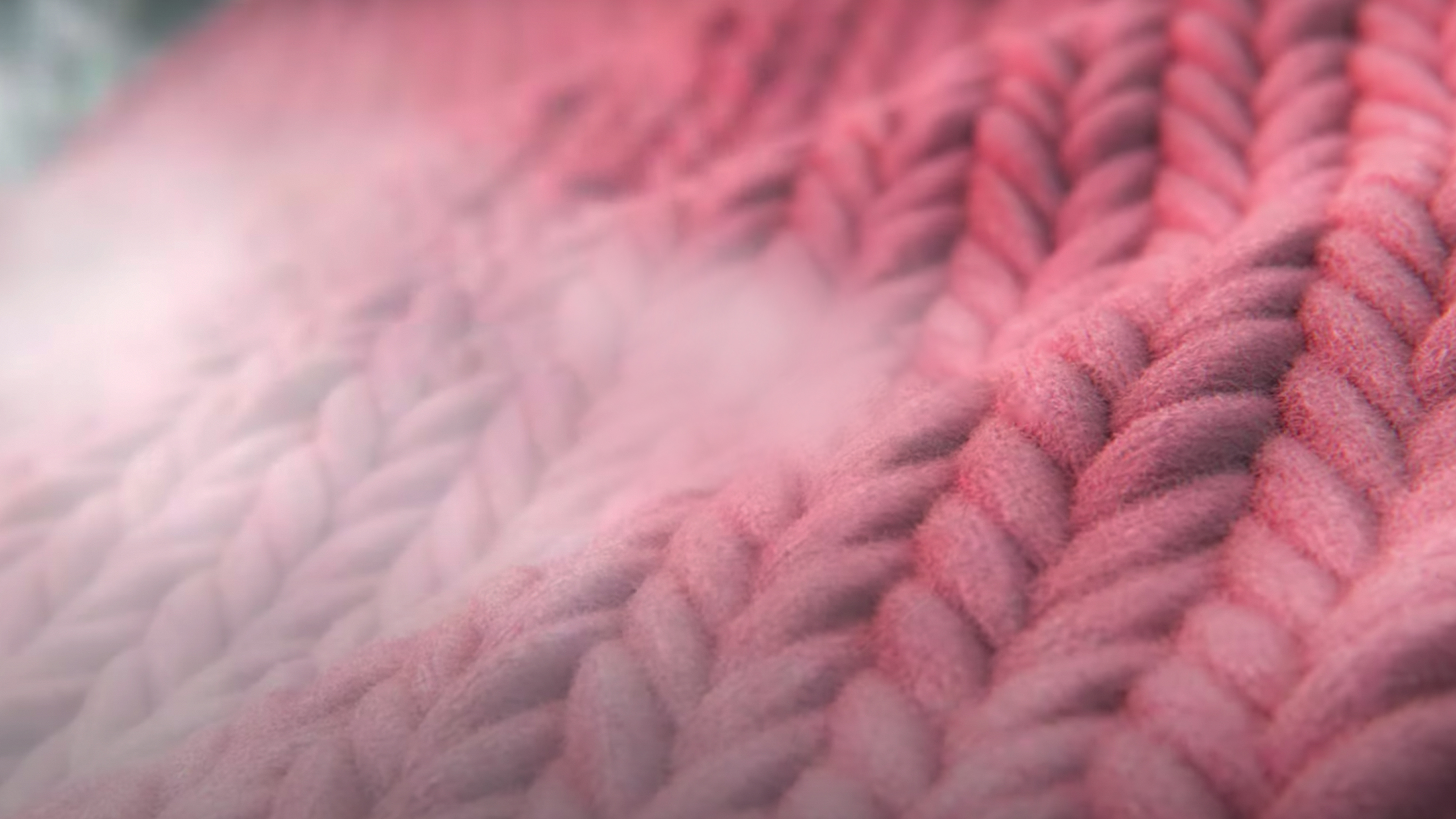 Primer plano de tejido de punto rosa, con un efecto de niebla en el lado izquierdo.