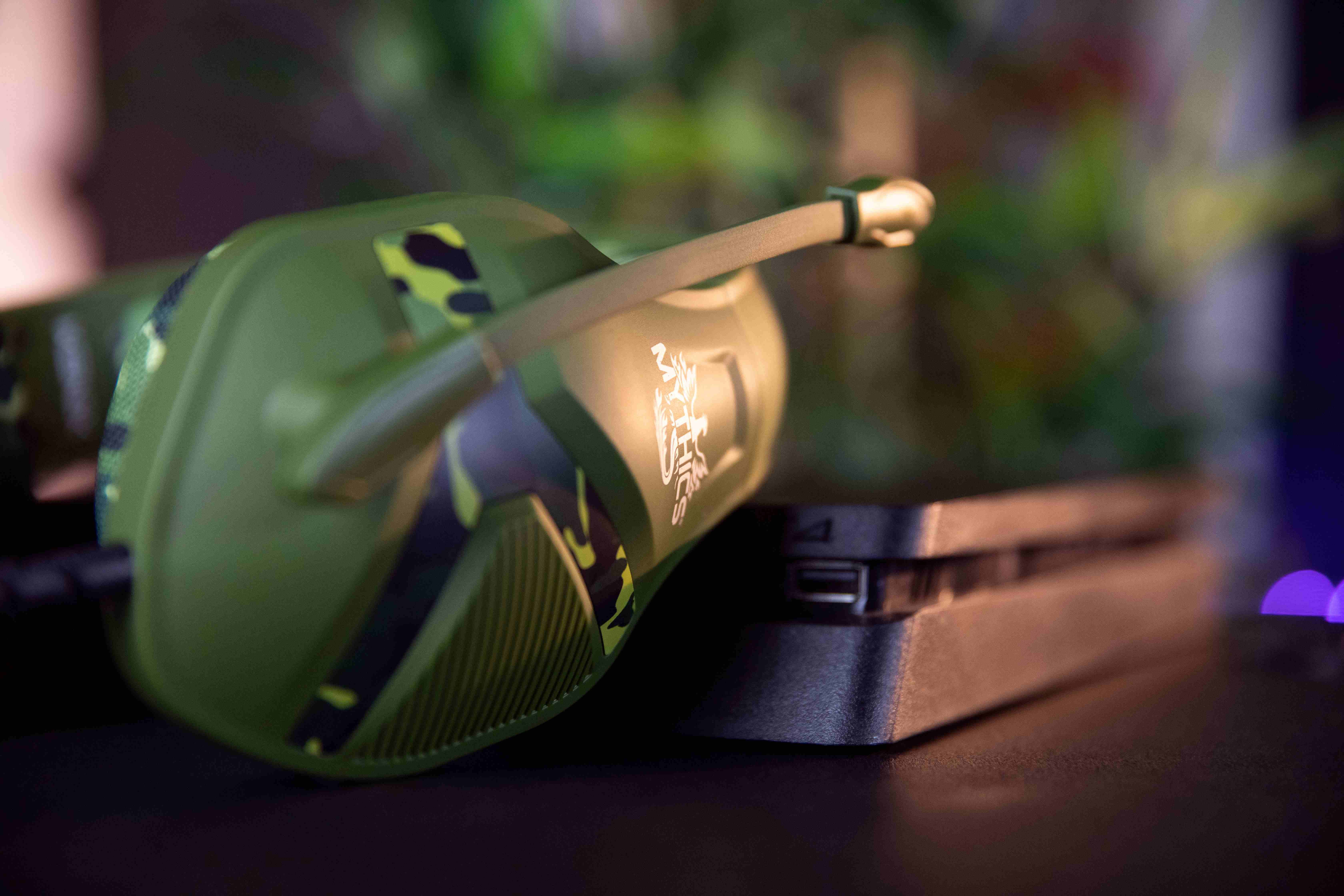Grünes und schwarzes Camouflage-Headset, auf einer Konsole, unscharfer Hintergrund.