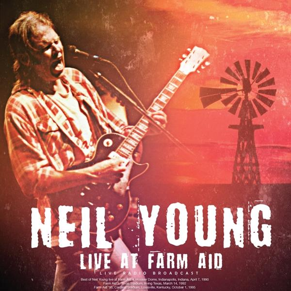 Neil Young gitározik, élőben a Farm Aid-en. A háttérben egy szélmalom látható. Az ég narancssárga-piros.
