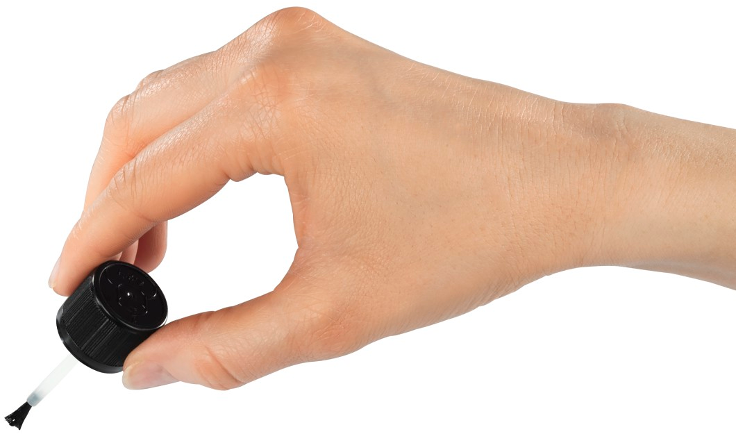 Hand hält schwarzen Nagellackpinsel.