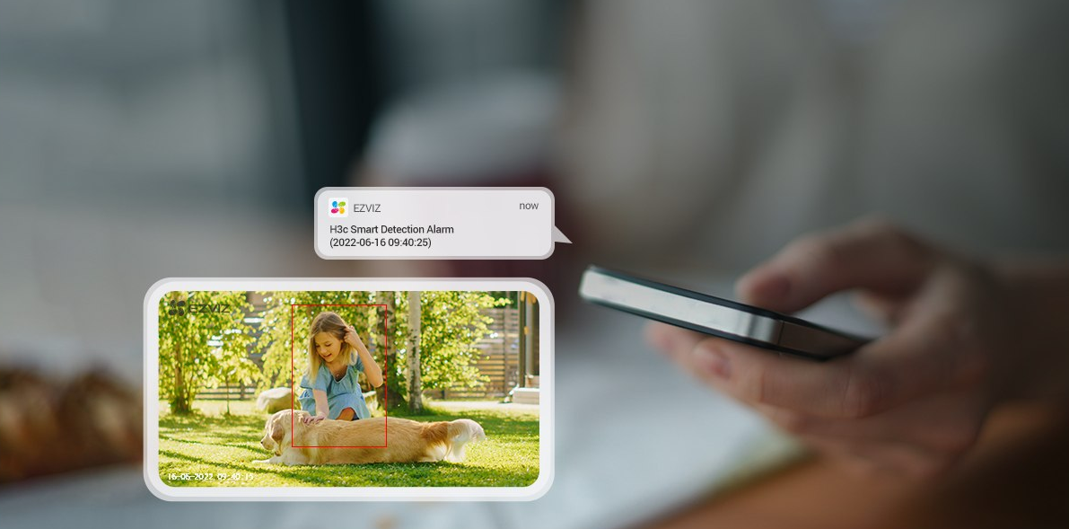Telefon, amely egy gyermeket és egy kutyát mutat, felül szöveges értesítéssel.
