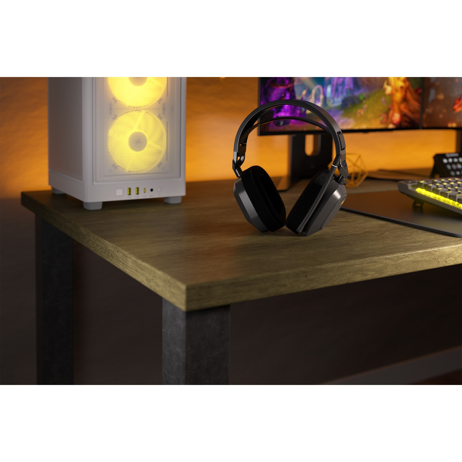 Un bureau avec un PC, un casque et un moniteur. Le PC a des ventilateurs éclairés en jaune.