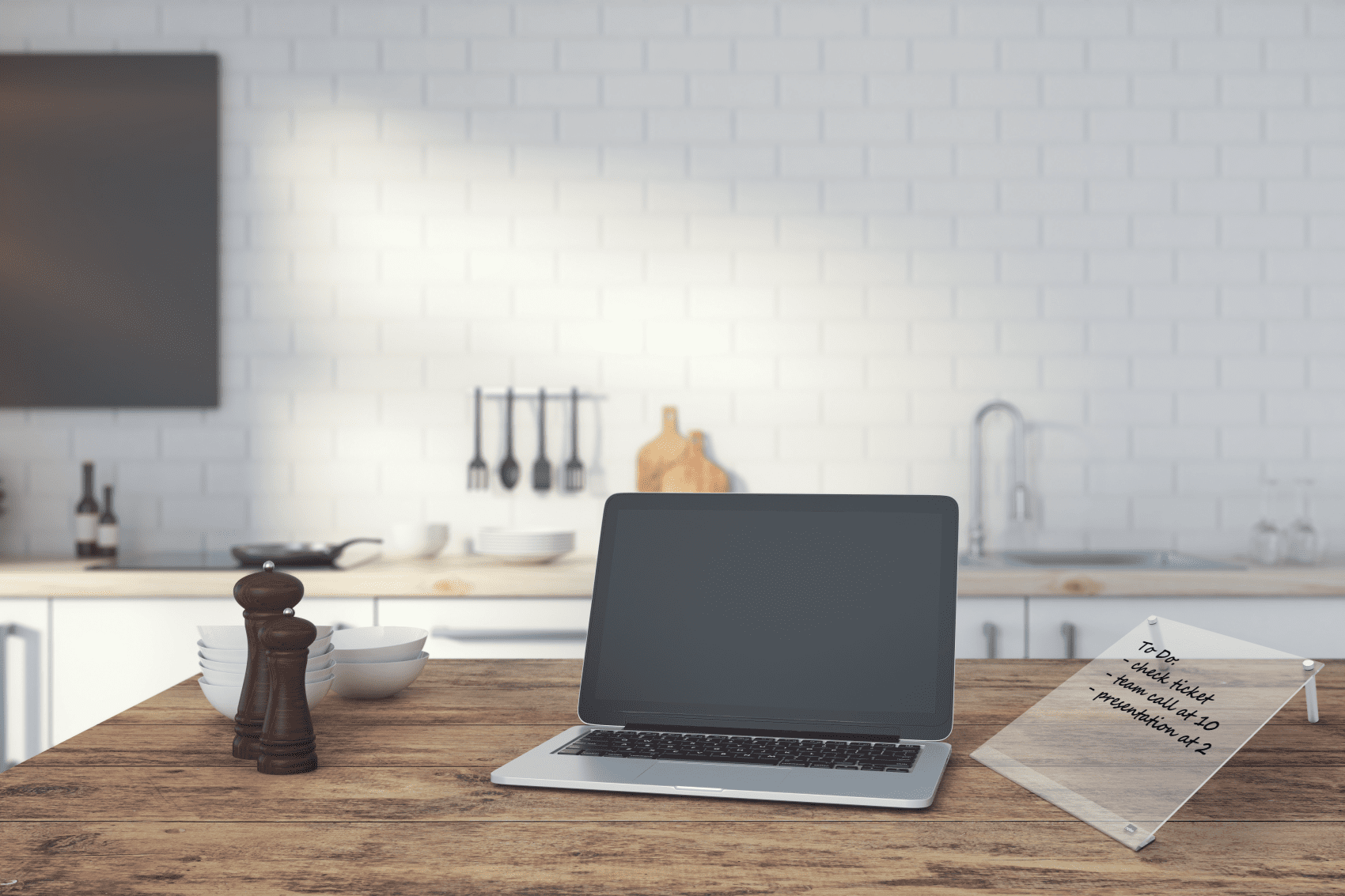 Egy laptop egy fa asztalon a konyhában, egy teendőlistával.