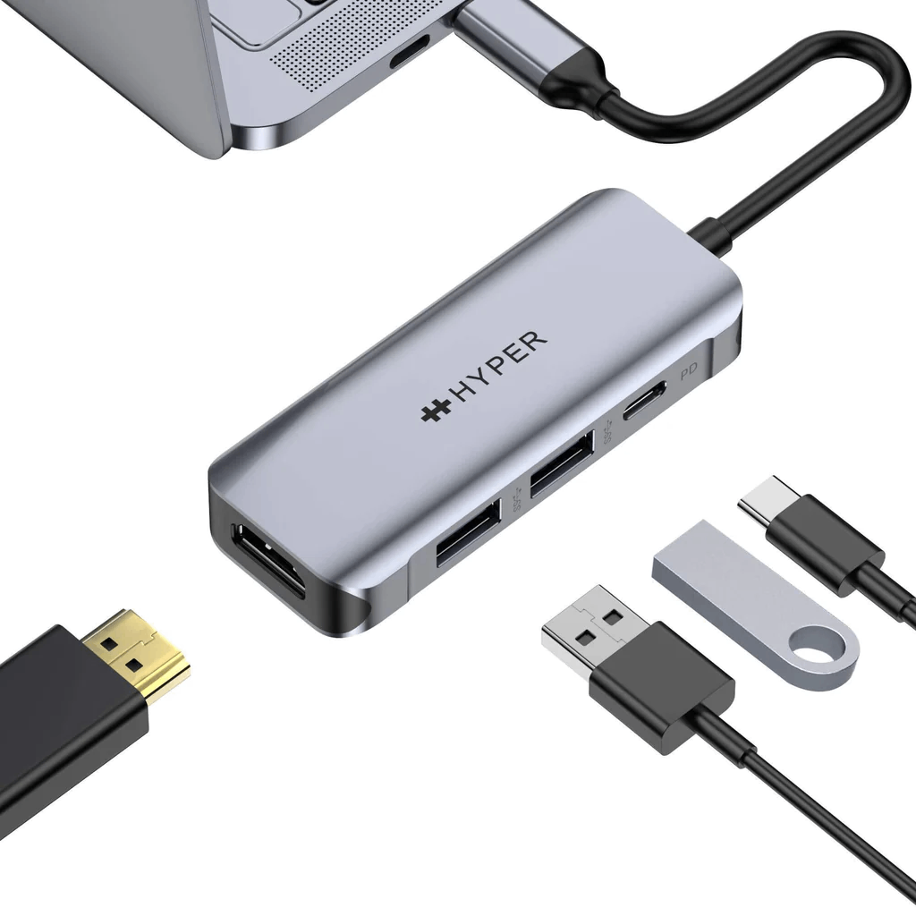 Un hub plateado con múltiples puertos conectado a un portátil y varios cables negros.