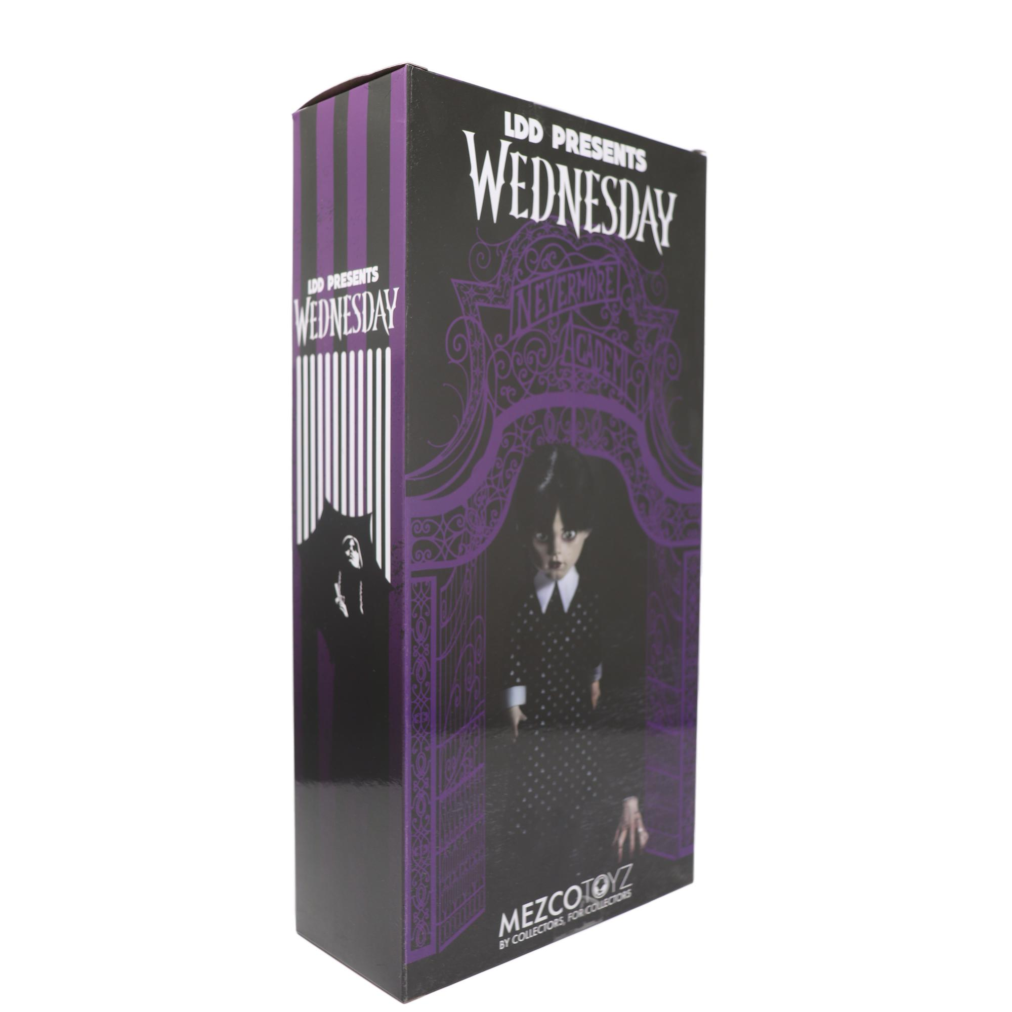 Eine hohe, schwarz-lila Schachtel für eine Wednesday-Puppe. Die Puppe ist durch die Schachtel sichtbar.