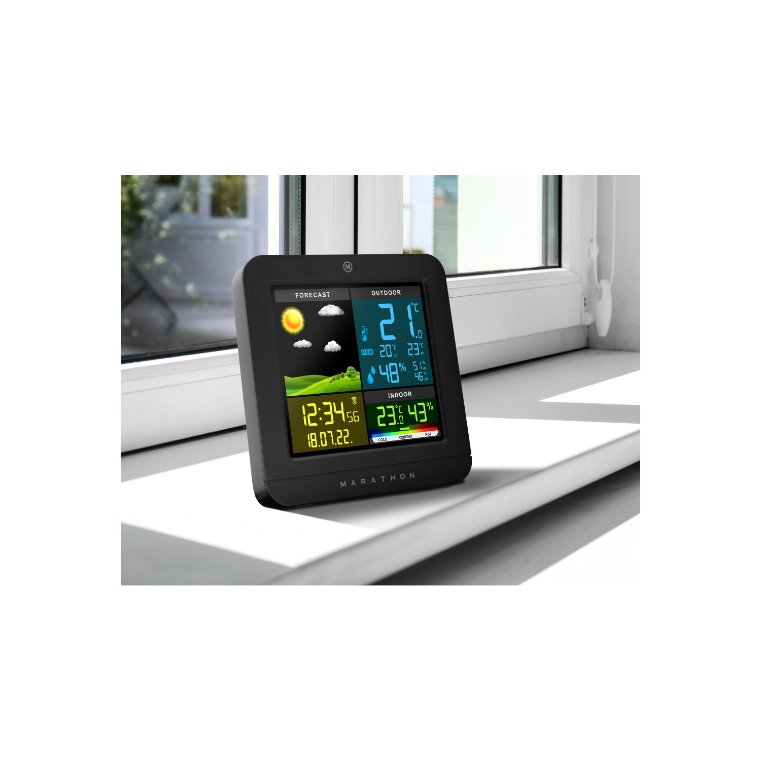 Black weather station on a windowsill, showing the forecast, outdoor and indoor temperatures and time.