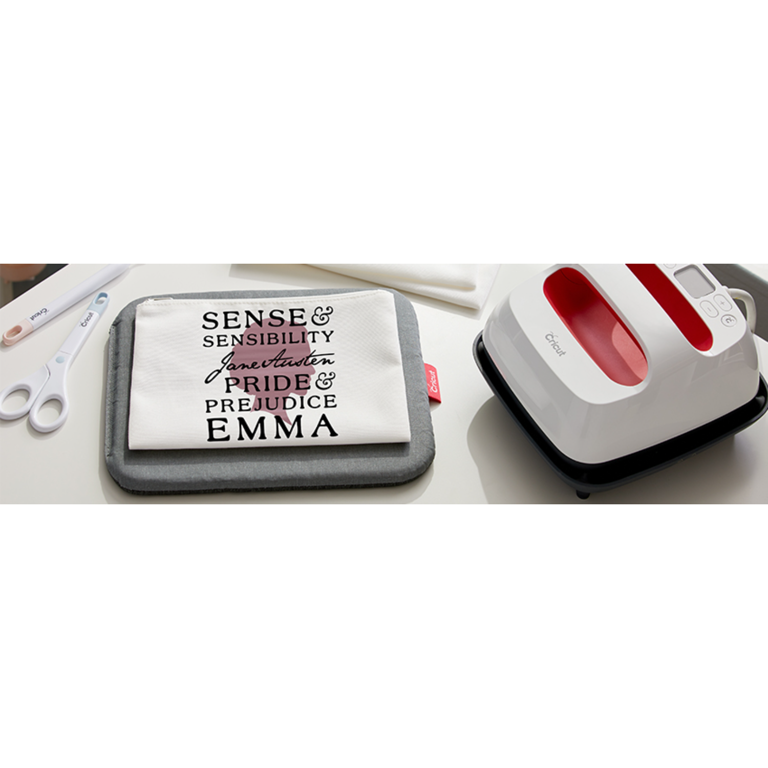 Een Cricut-machine en een boekomslag met tekst: Sense & Sensibility, Pride & Prejudice, Emma.