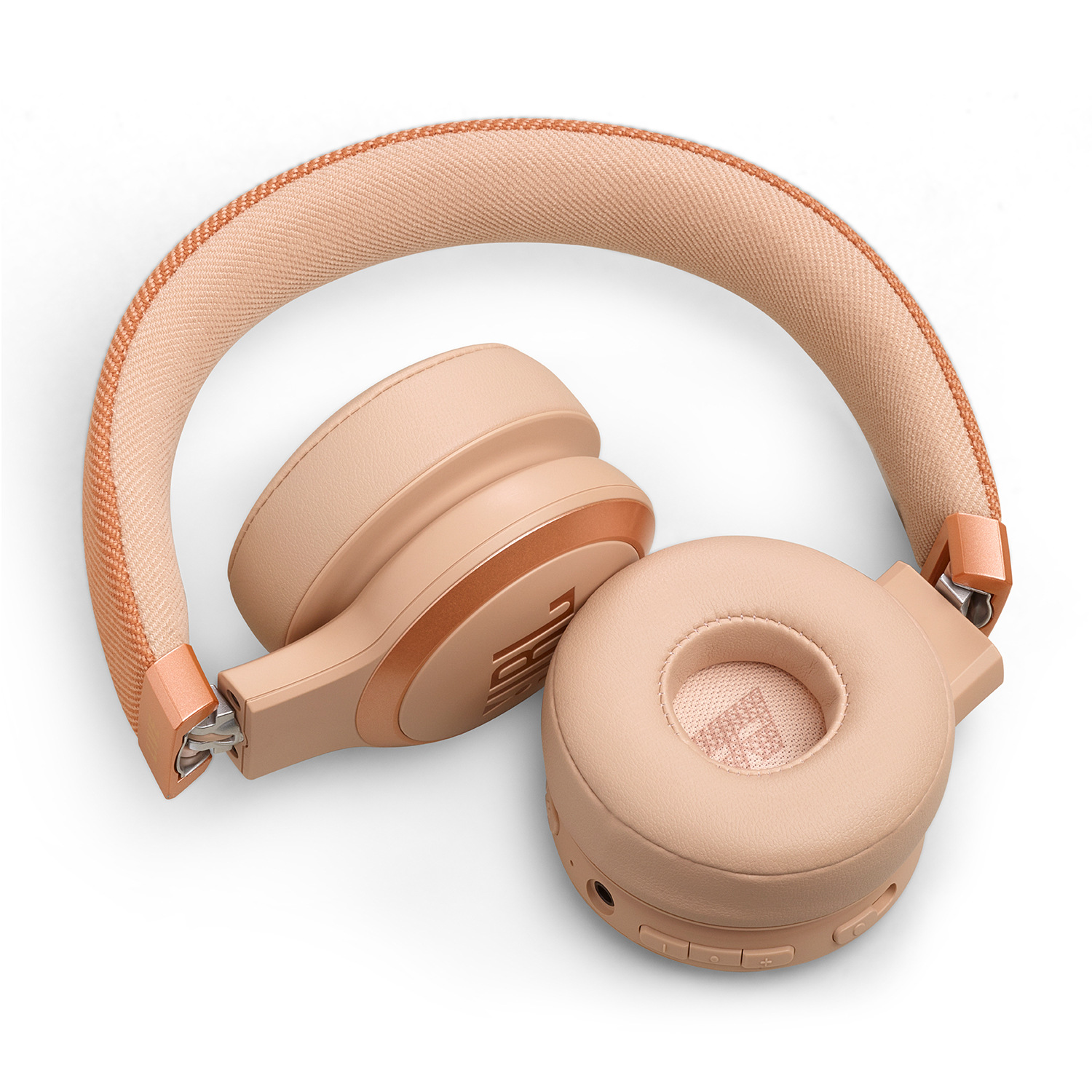 Cuffie rosa sovraurali, piegate, su una superficie bianca. I padiglioni sono beige, l'archetto rosa.