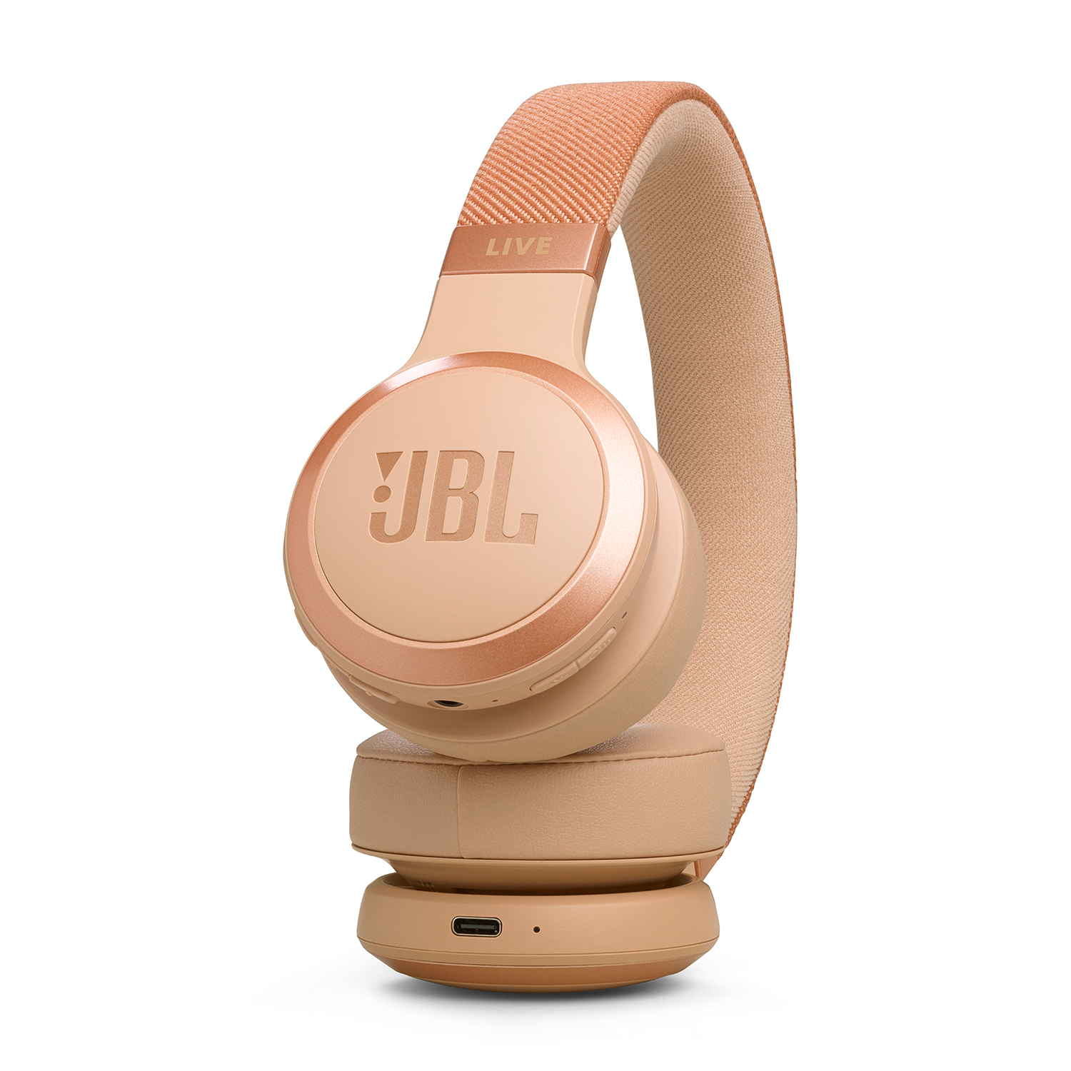 Un paio di cuffie JBL rosa chiaro. Le cuffie sono over-ear e hanno una fascia rivestita in tessuto.