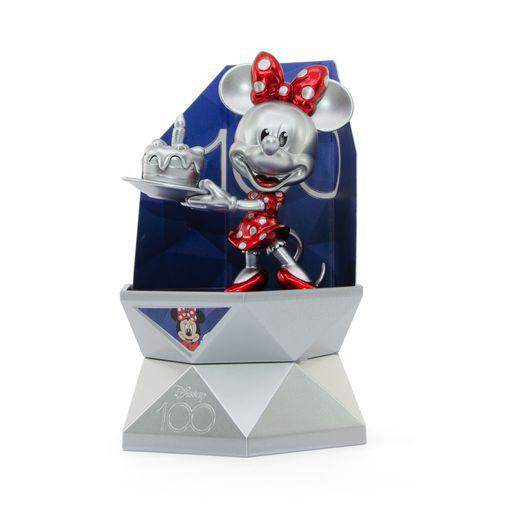 Minnie-Maus-Statue mit Kuchen, auf geometrischer Basis, mit blauem Hintergrund.