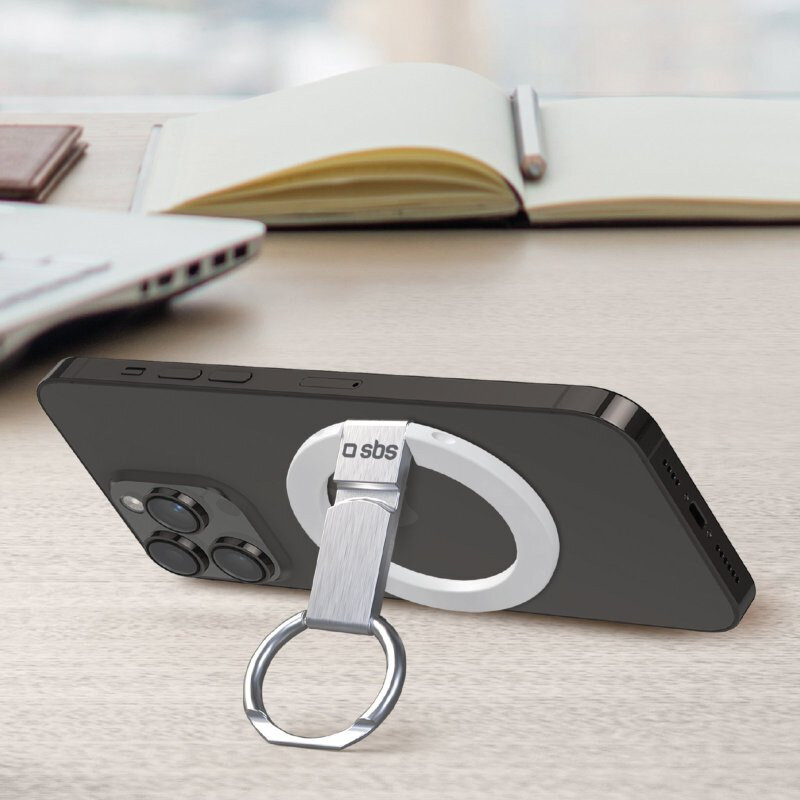 Czarny telefon ze srebrnym uchwytem na pierścień, na drewnianej powierzchni z książką.