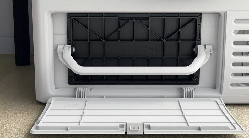 Komora filtra kłaczków pralki, otwarta, pokazująca biały uchwyt i czarny filtr.