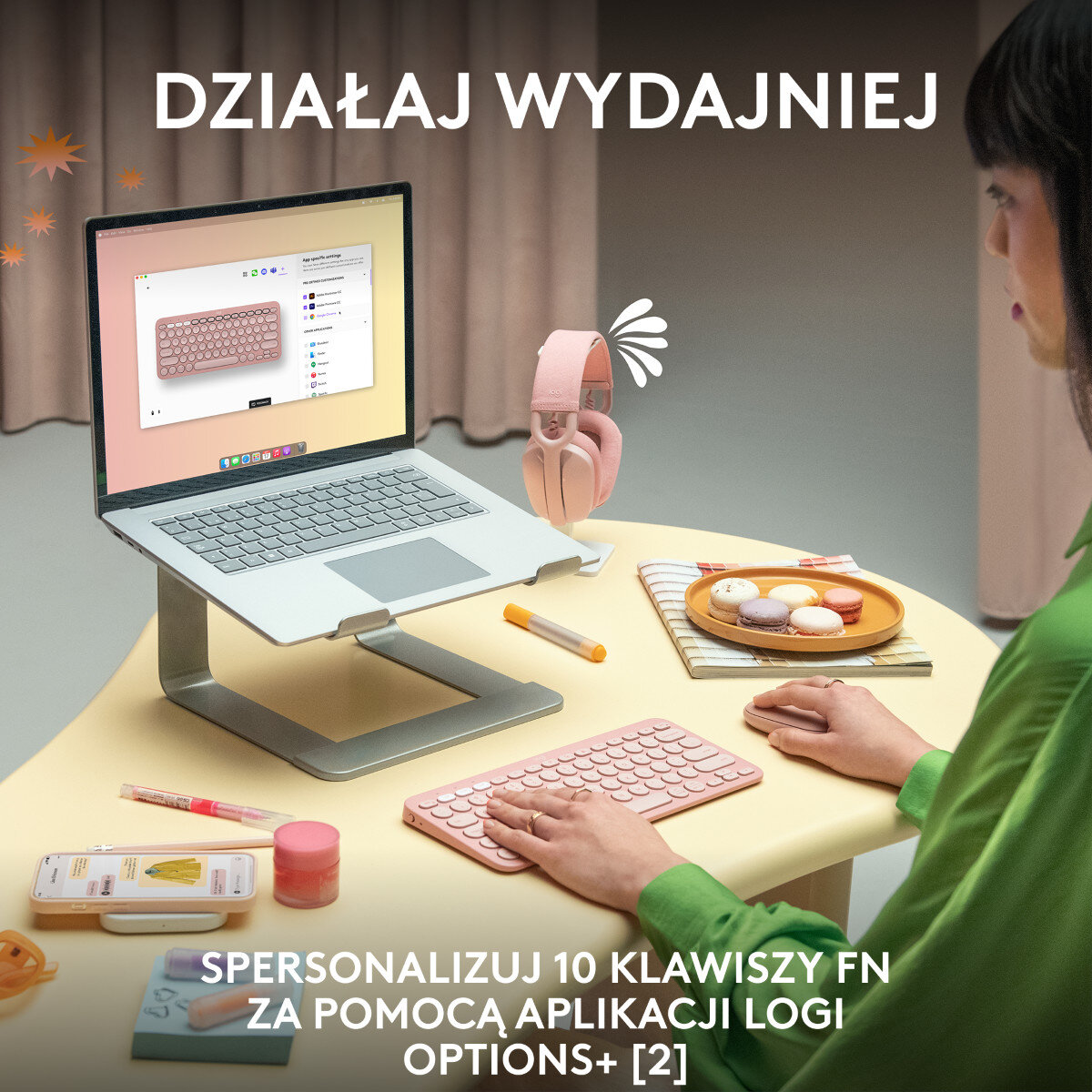 Kobieta używająca laptopa na podstawce, z różową klawiaturą i słuchawkami oraz myszką na stole.