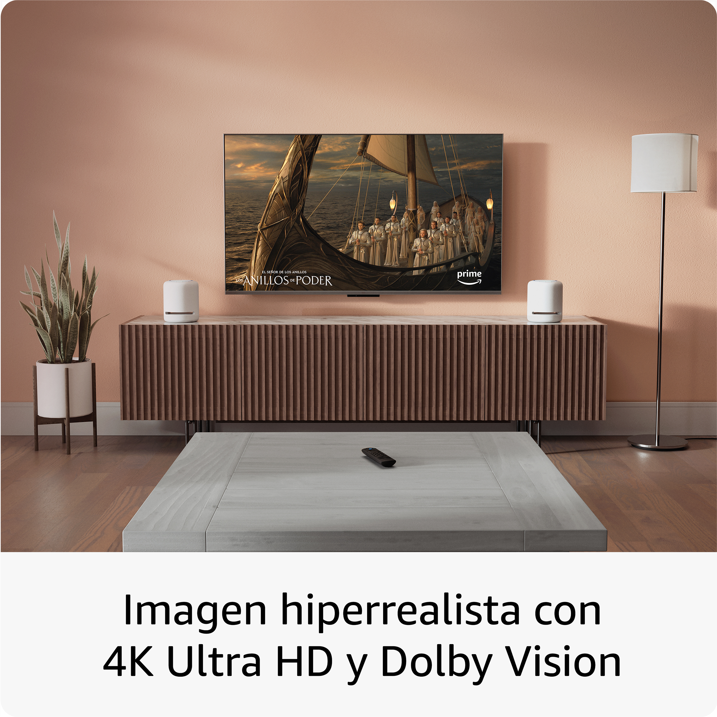 Salón con TV mostrando una escena de Los Anillos de Poder. Hay un mueble, altavoces y una mesa.