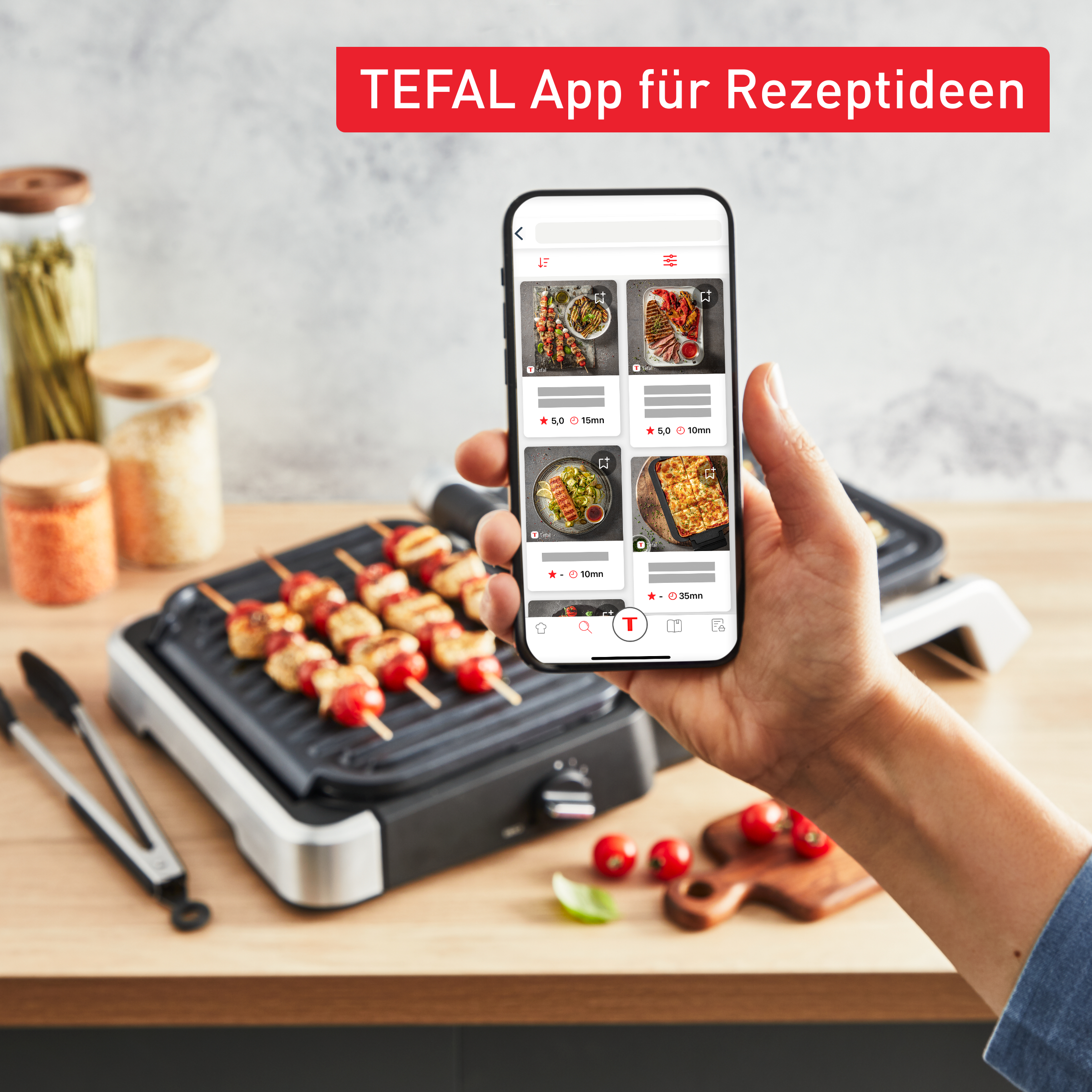 Person hält Telefon mit Essensbildern, Grill und Zutaten auf Tisch.