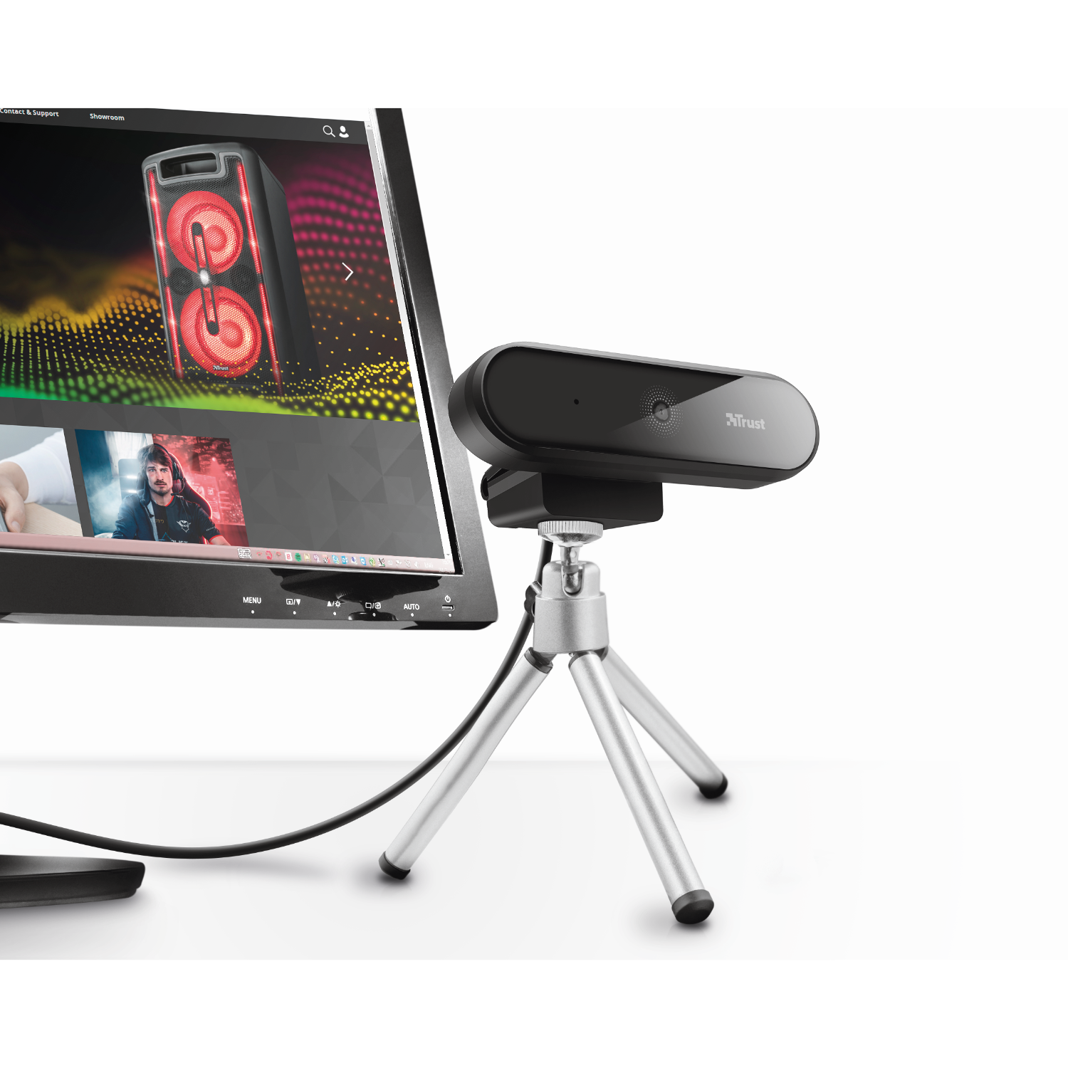 Black Trust webcam on a silver tripod, in front of a computer monitor.