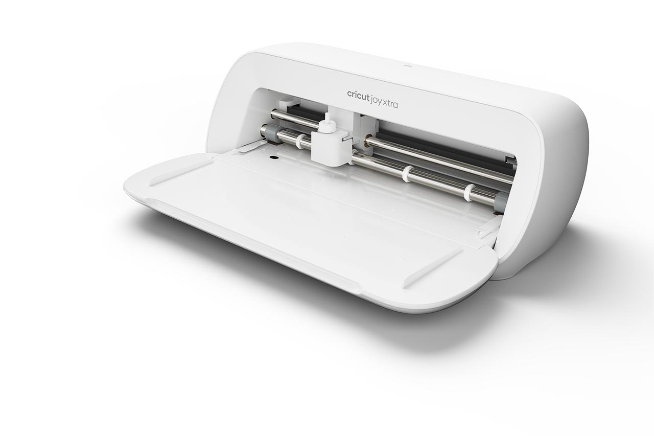 Weiße Cricut Joy Xtra Maschine, geöffnet, mit sichtbarem Schneidebereich, weißer Hintergrund.