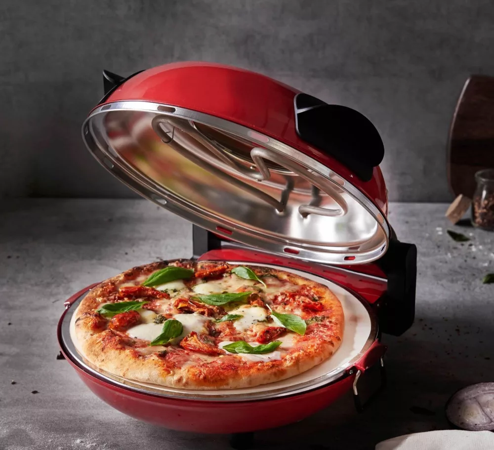 Piros pizzakemence nyitott fedéllel, benne pizza. Szürke háttér.
