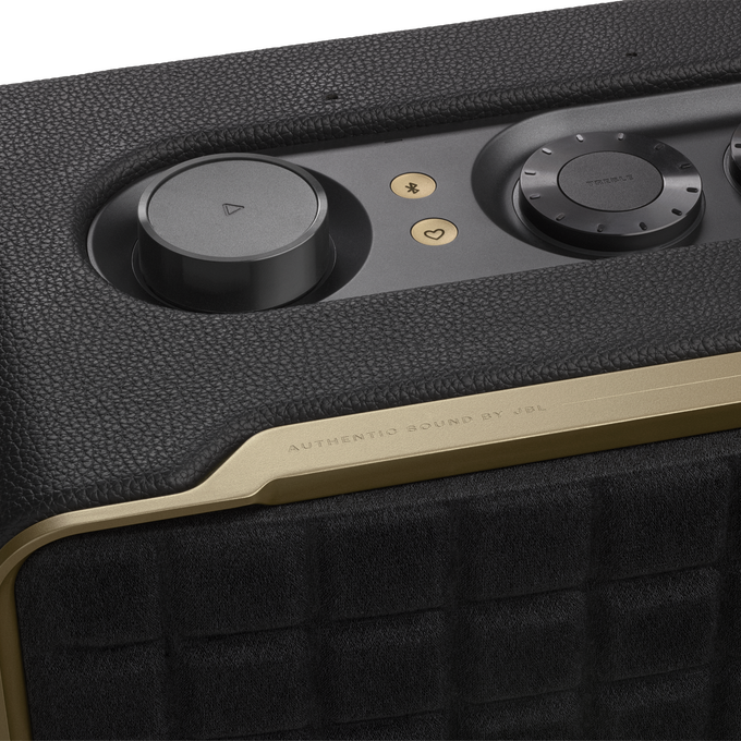 Primer plano del altavoz. Cuero negro, detalles dorados y controles.