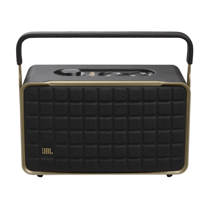 Un altavoz JBL negro con asa. El altavoz tiene forma cuadrada y detalles dorados.