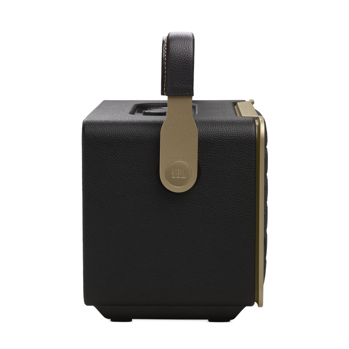 Altavoz JBL negro con asa. Detalles dorados y textura similar al cuero.