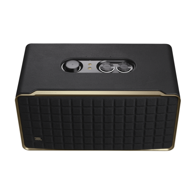 Un altavoz negro con adornos dorados y perillas de control en la parte superior.
